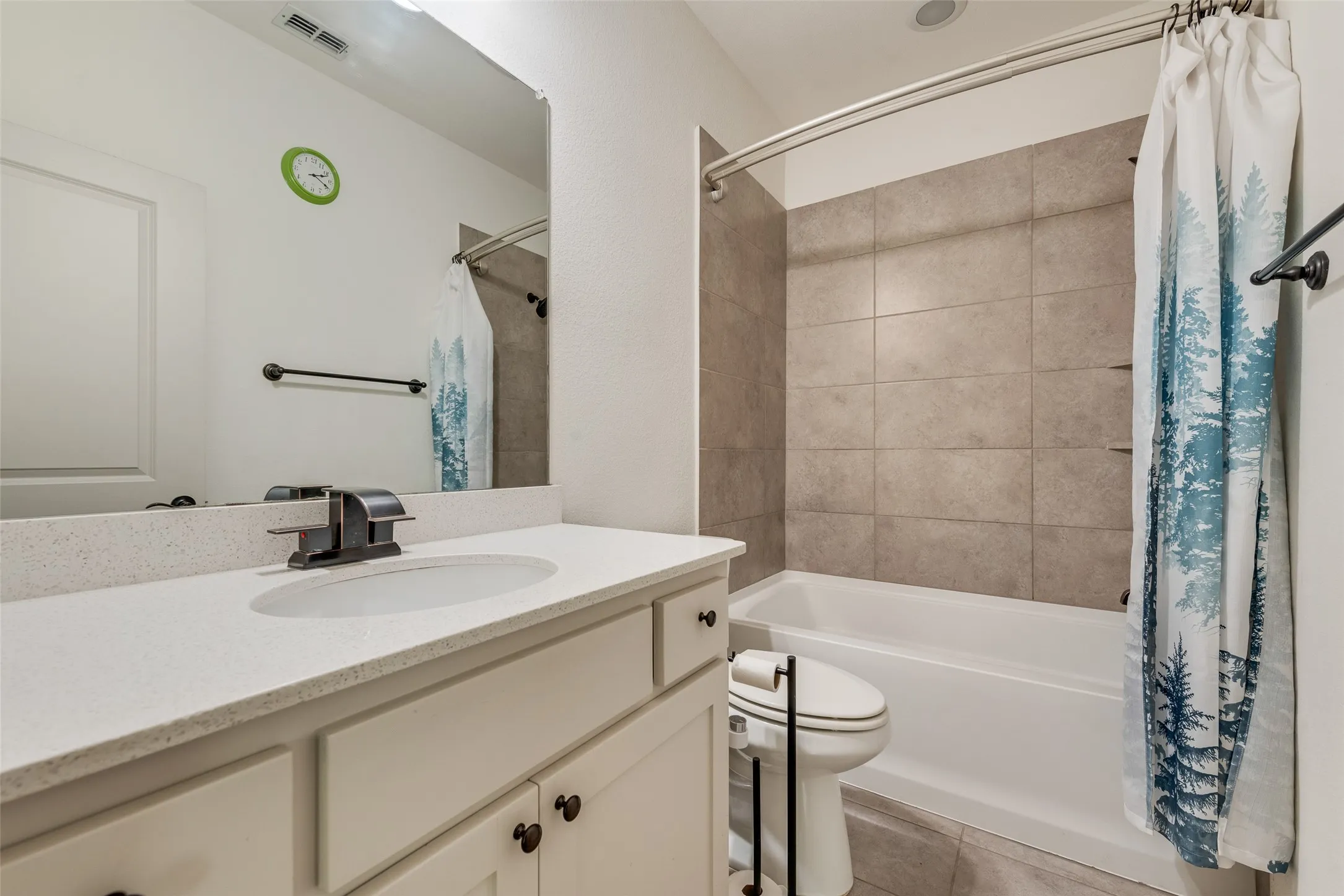 Bathroom vanity featuring a light-colored countertop, undermount sink, and dark-finish faucet