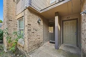 Exterior featuring a brick facade, siding accents, an overhead entry canopy, and a paneled entry door