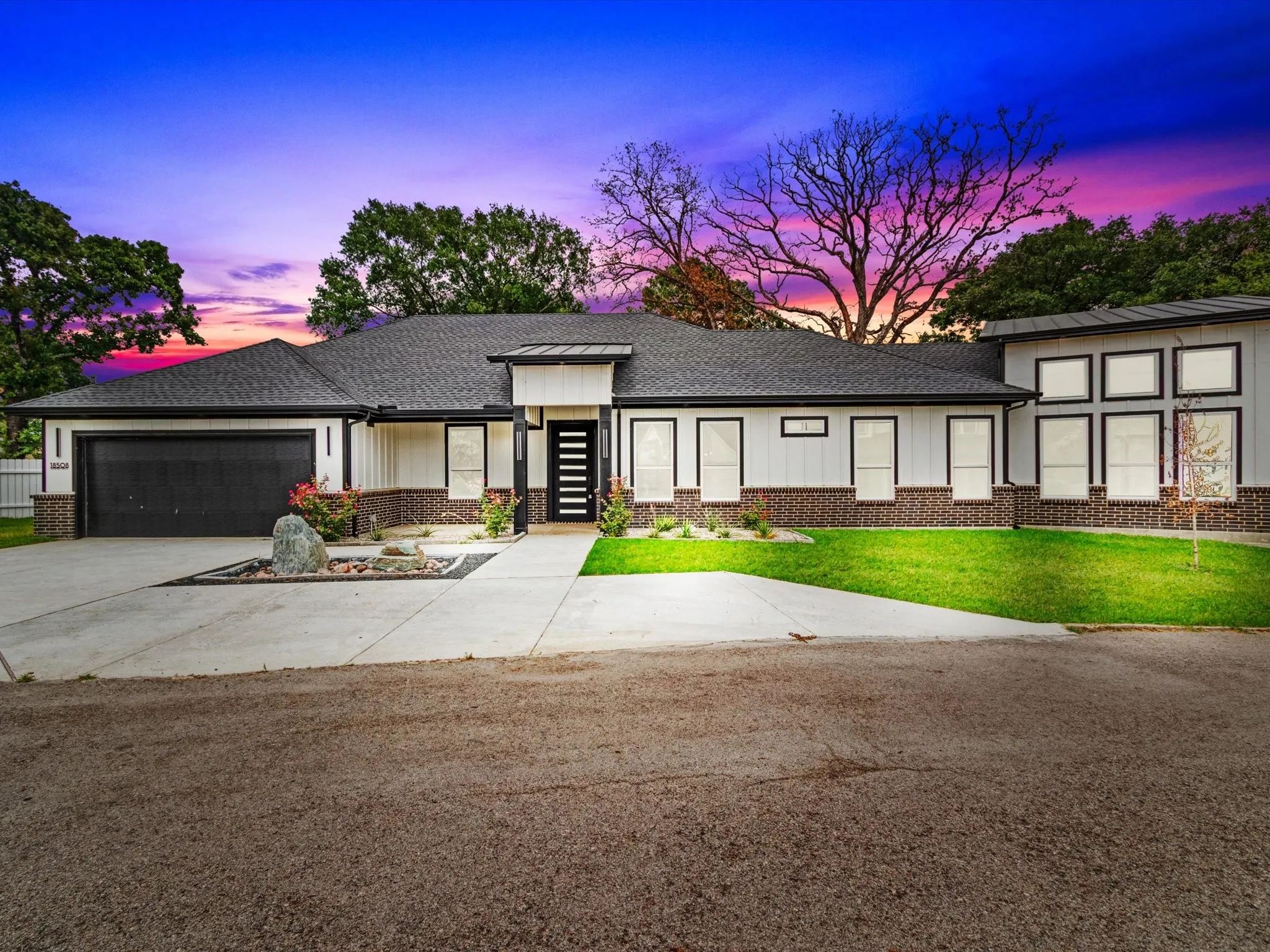Contemporary exterior featuring vertical siding accents and a contrasting dark brick foundation