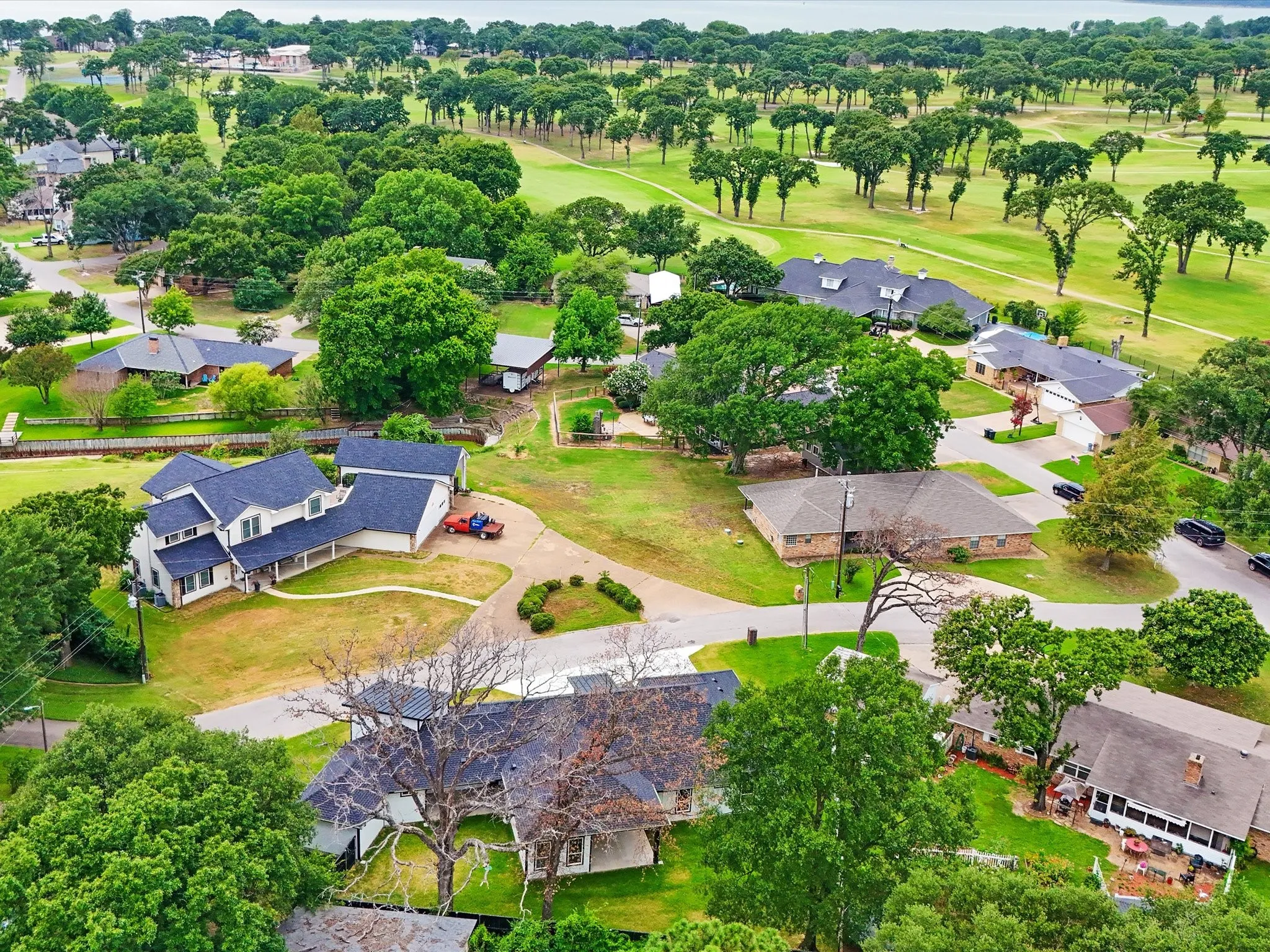 Aerial perspective showcasing a residential property with a multi-gabled roofline and surrounding green spaces