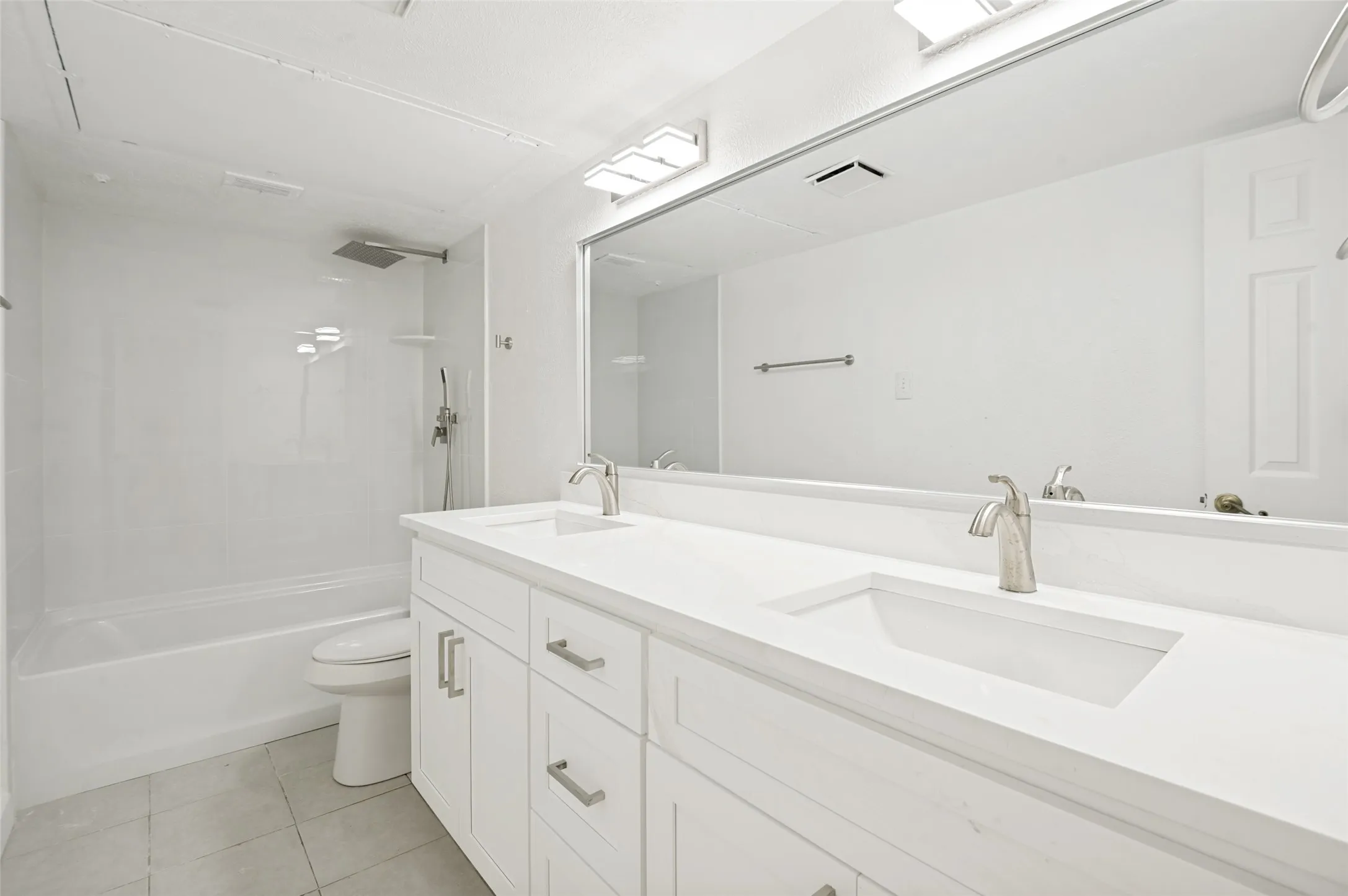 Bathroom featuring a double vanity with white cabinetry and integrated sinks
