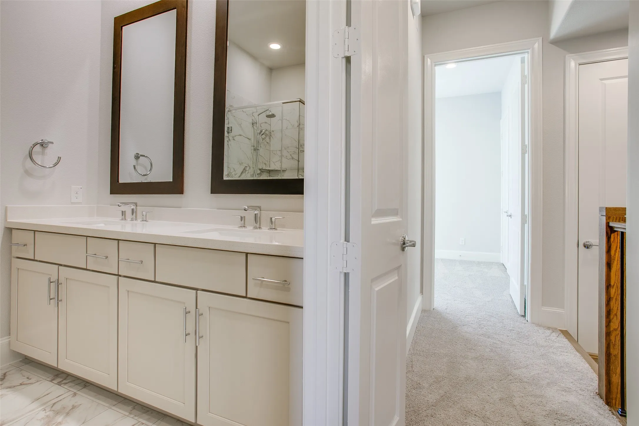 Dual vanity featuring white shaker-style cabinetry, undermount sinks, and chrome fixtures