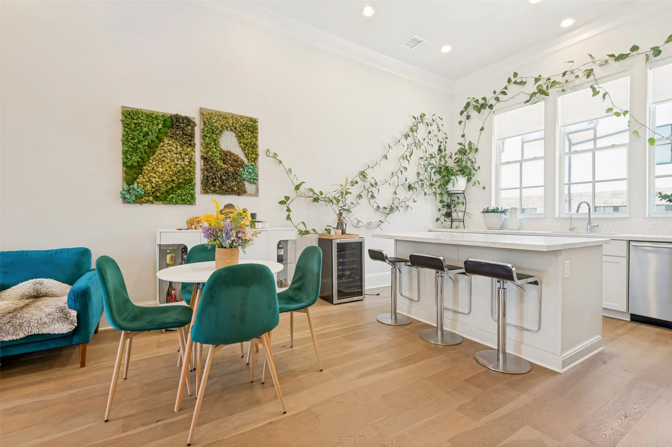 Open-concept interior featuring light wood-finish flooring, white walls, and crown molding