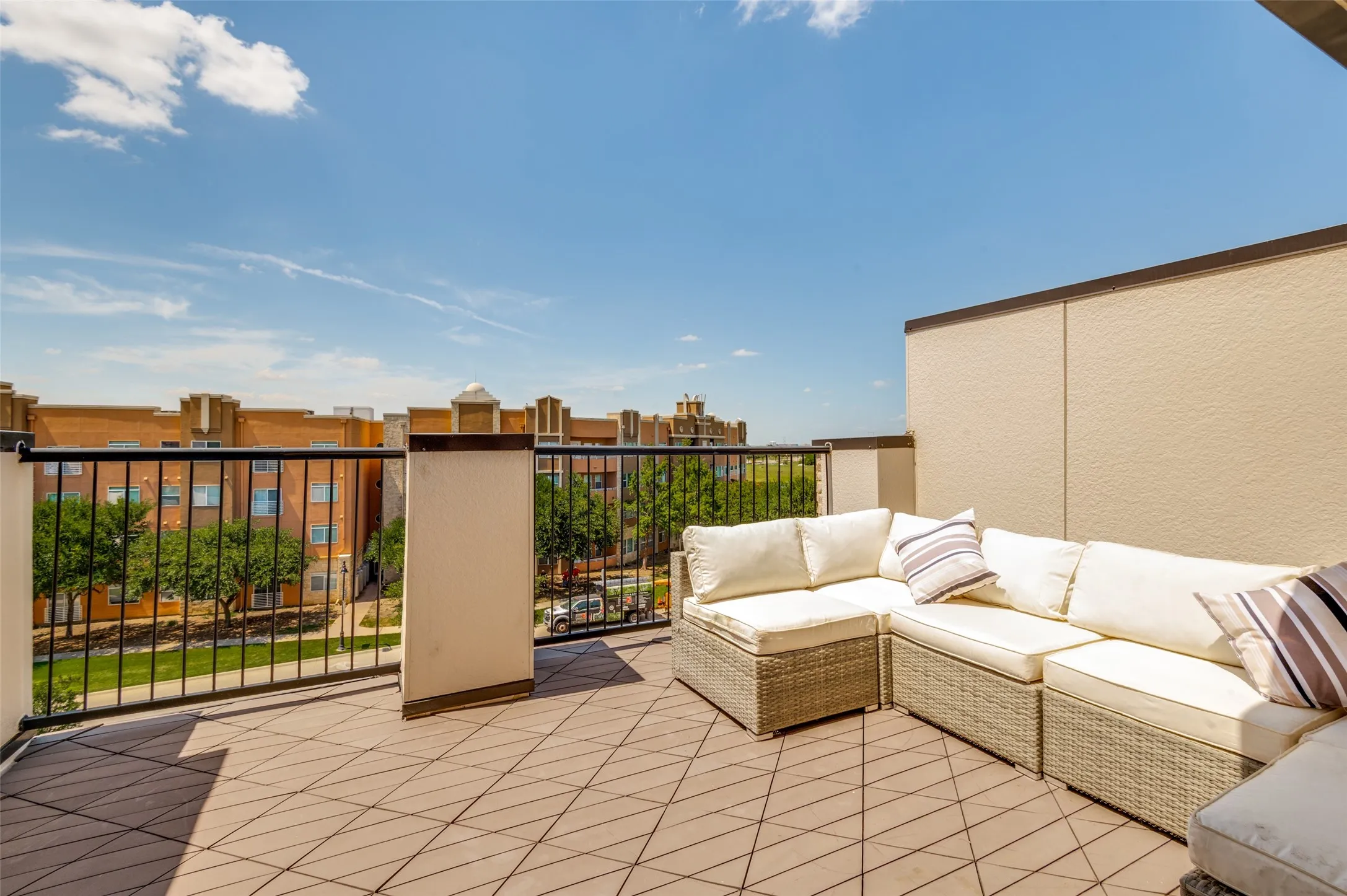 Rooftop patio featuring tiled flooring and black metal railing