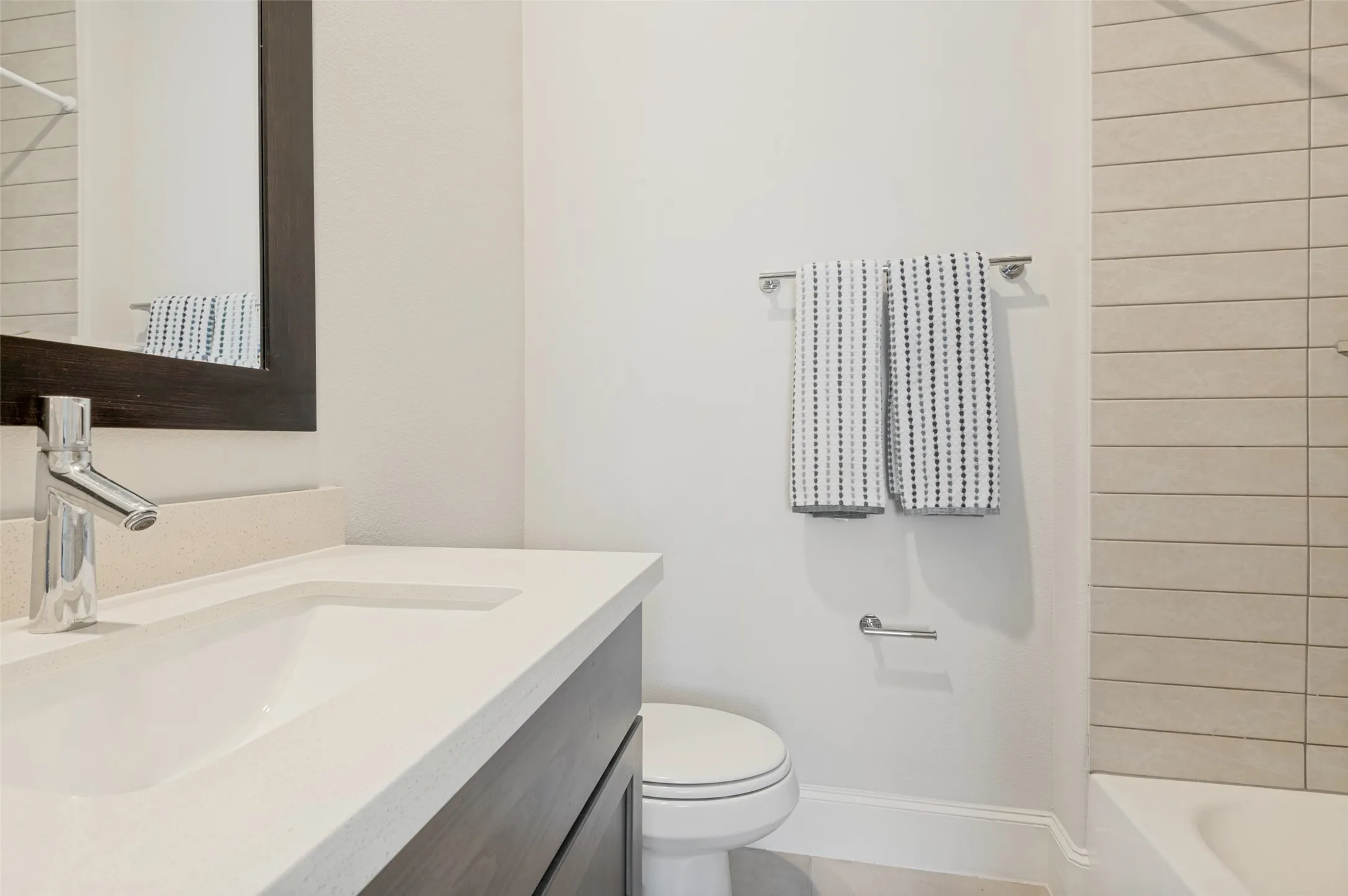 Bathroom featuring a vanity with a light-toned countertop, integrated sink, and a chrome faucet