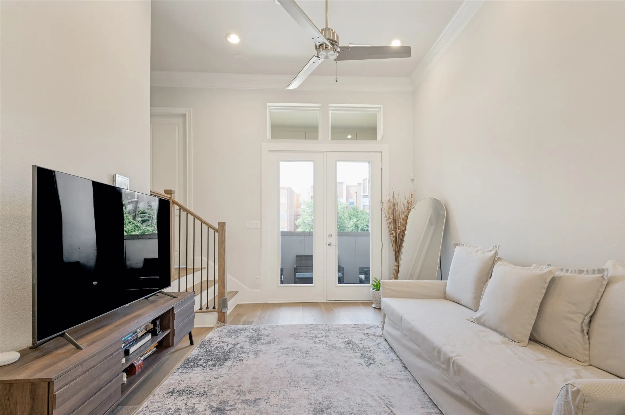 Living area featuring wood-finish flooring, white walls, and recessed lighting