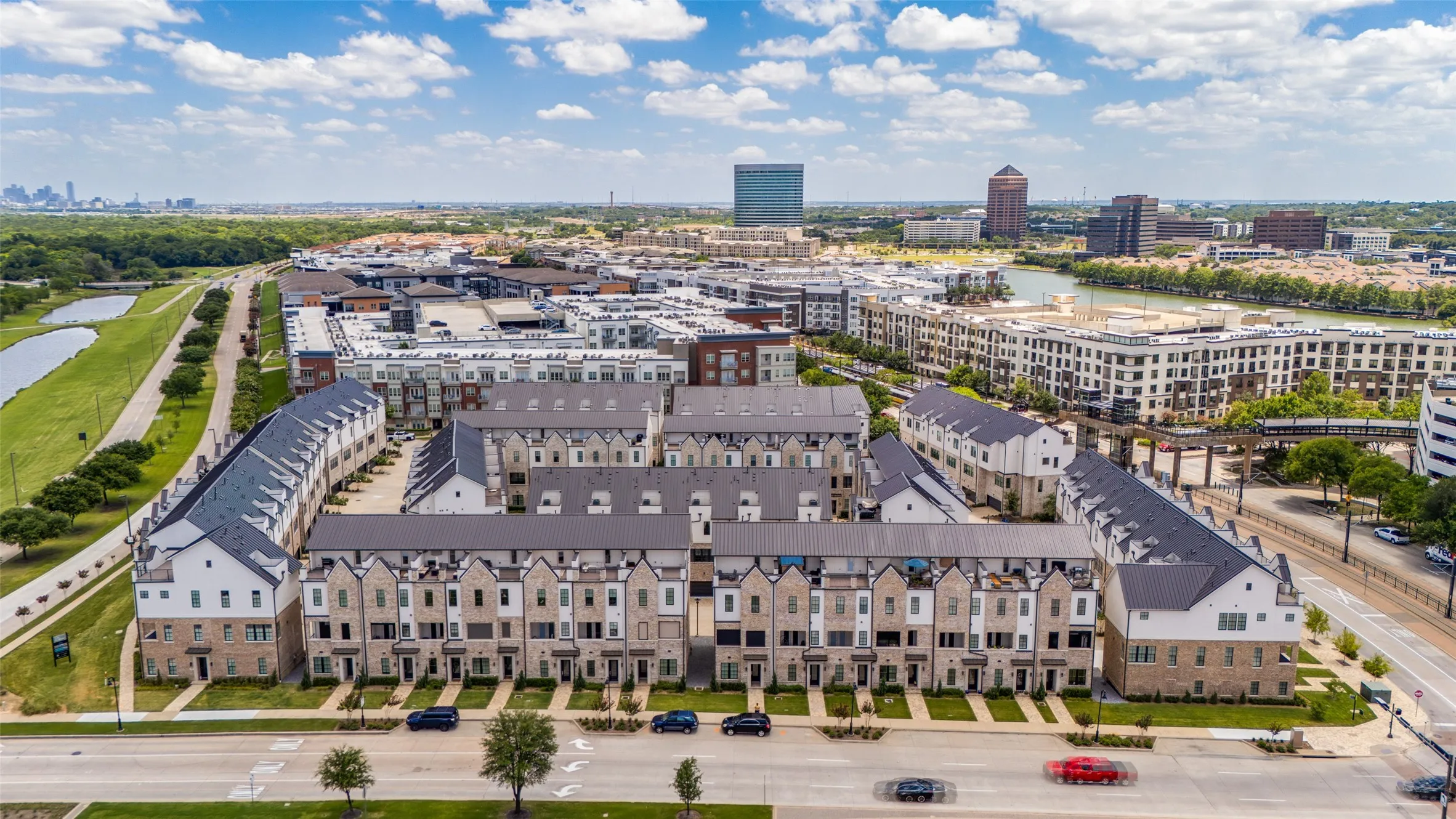 Aerial perspective showcasing a modern townhome community with stone and siding exteriors and dark-toned roofs
