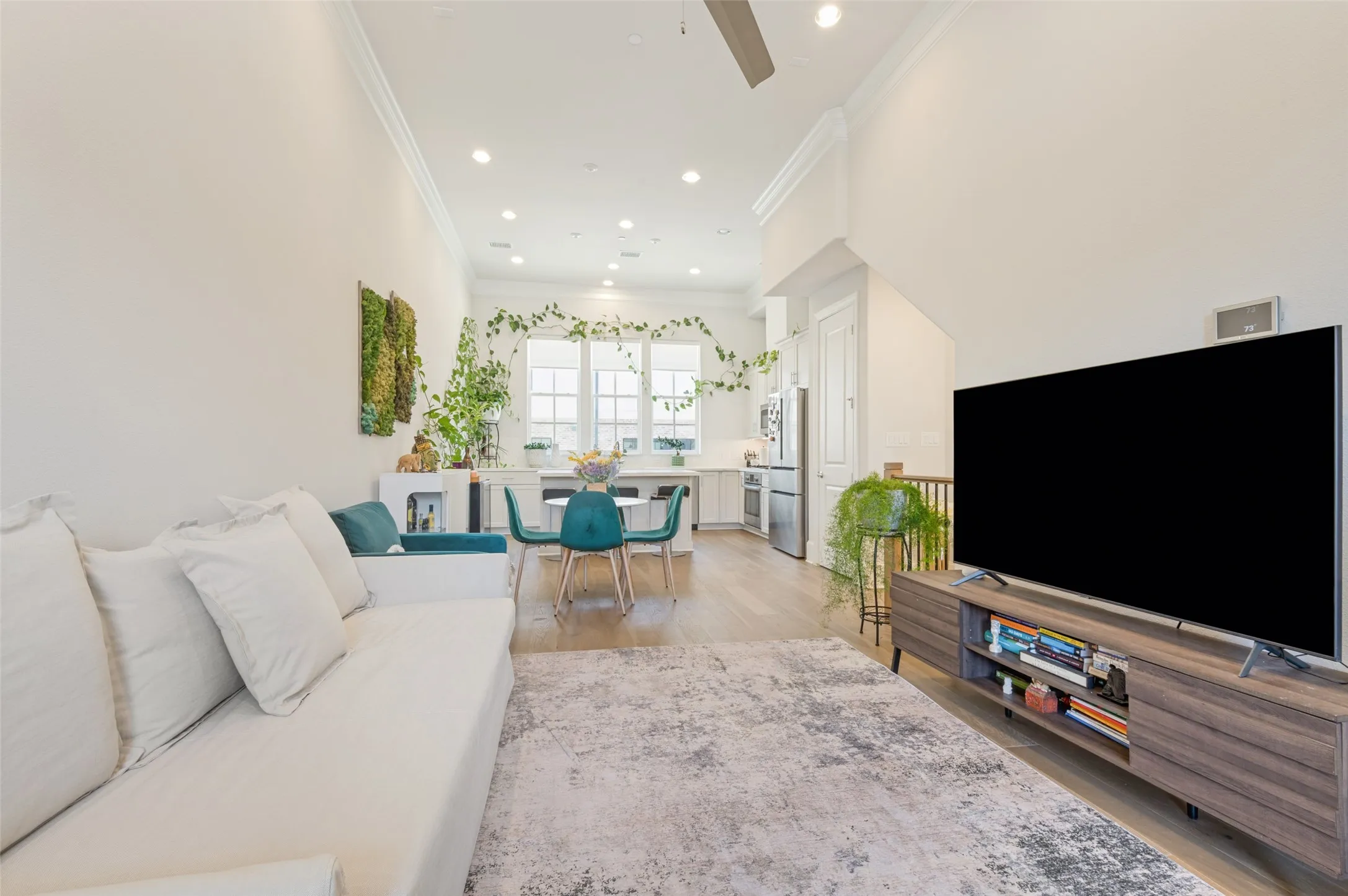 Open-concept living area featuring high ceilings, recessed lighting, and wood-finish flooring