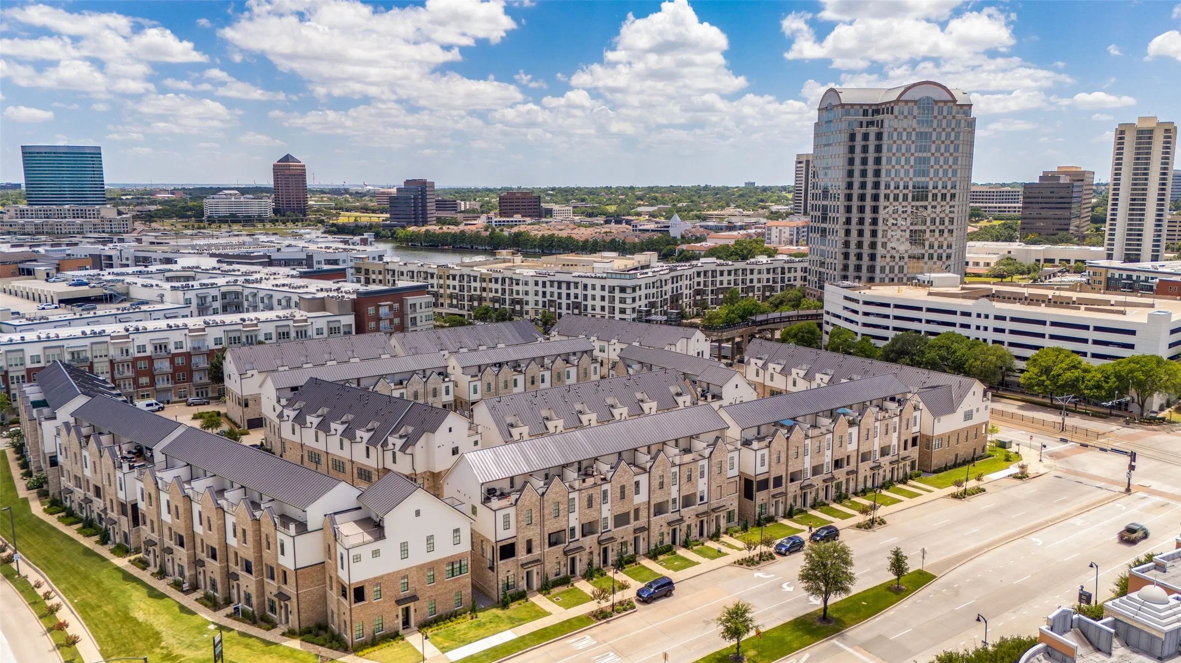 Contemporary townhome community featuring multi-level facades, gabled roofs, and brick and stucco exteriors