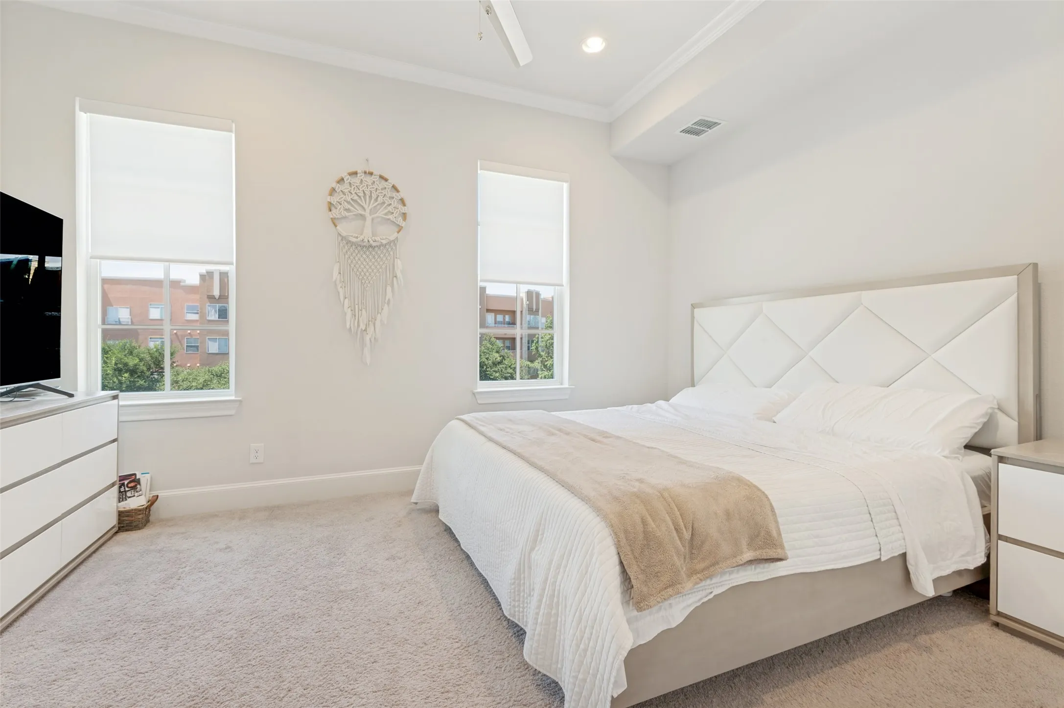 Carpeted room featuring two windows with roller shades, a ceiling fan, recessed lighting, and crown molding