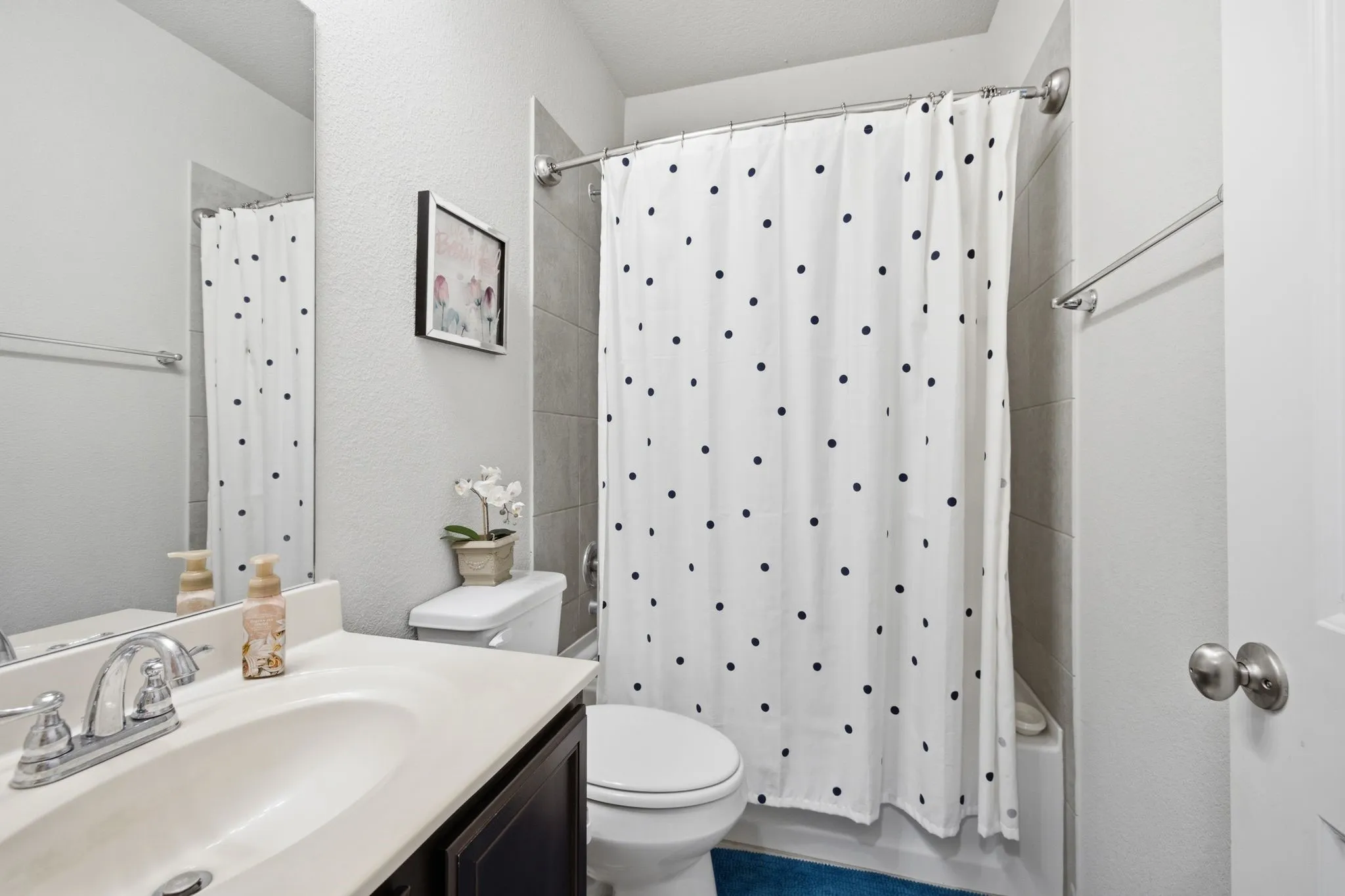 Full bathroom featuring a single vanity with an integrated sink, a toilet, and a tiled shower/tub combination