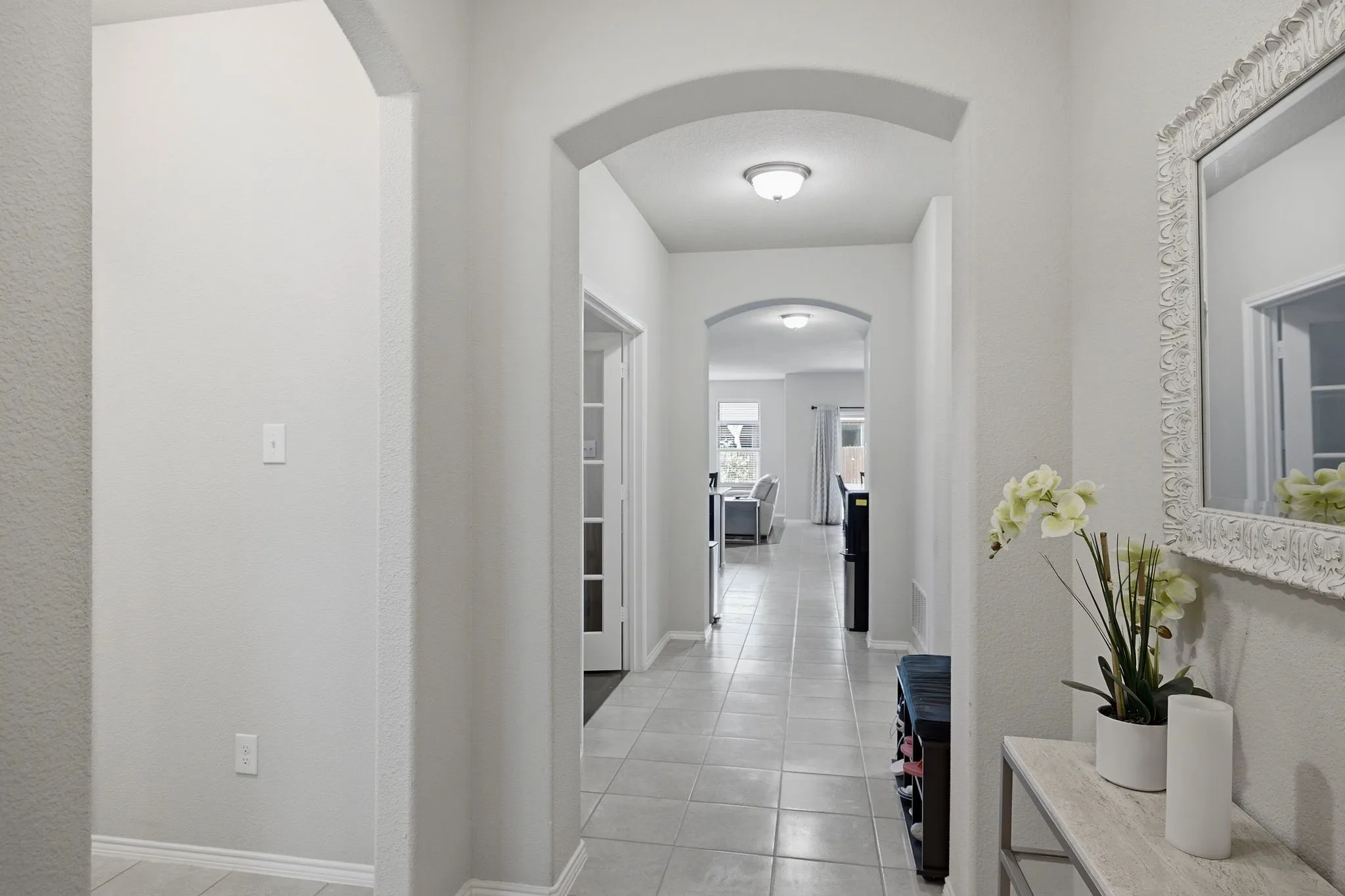 Arched entryways featuring light gray wall tones and tile flooring throughout