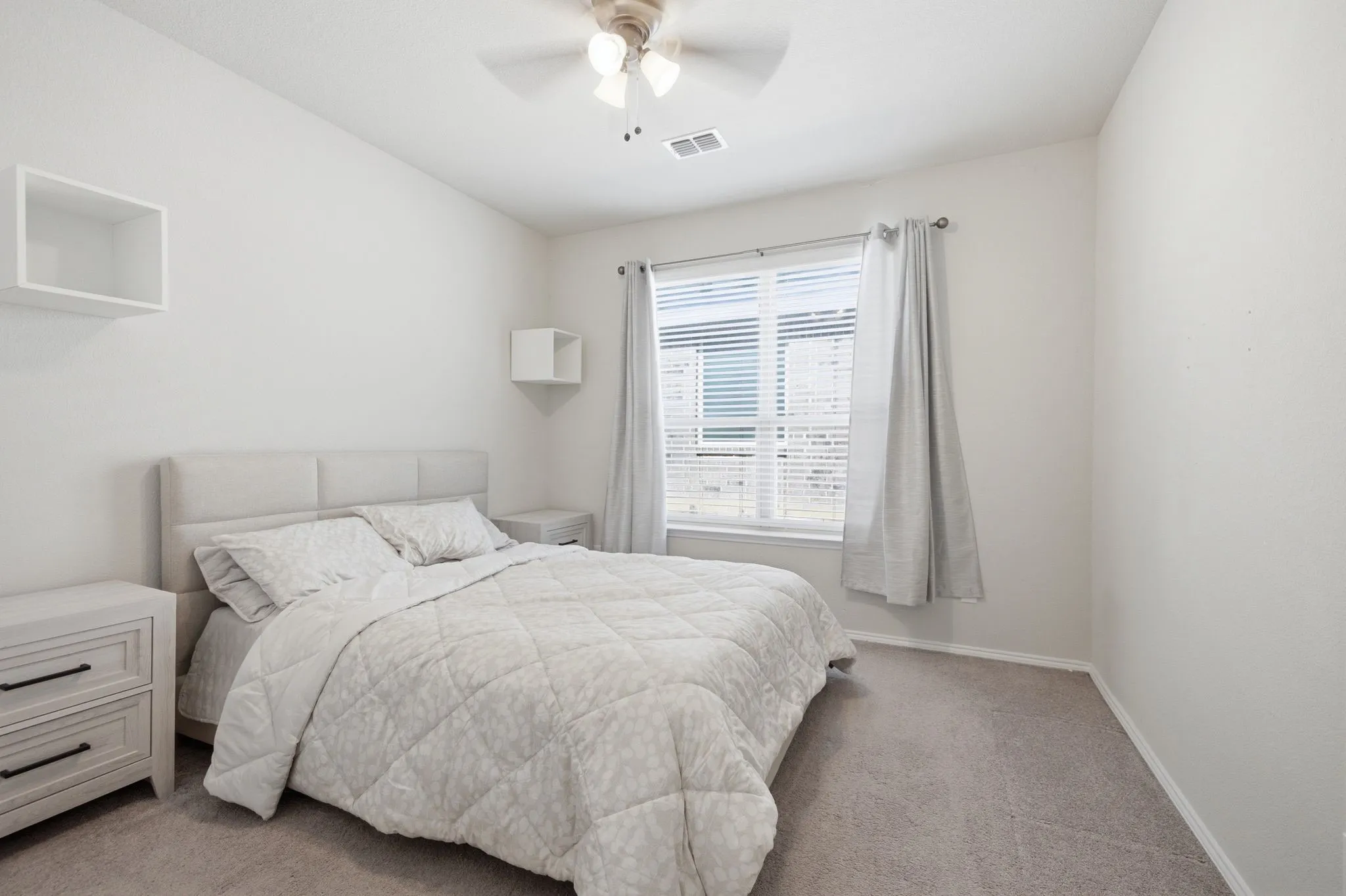 Carpeted room with a ceiling fan, a window with blinds, and white walls