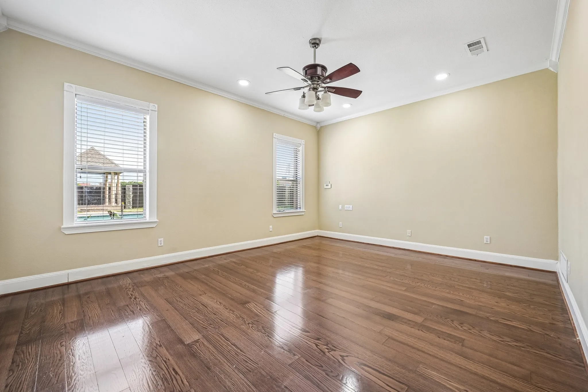 Expansive primary suite with French doors to lush backyard with pool