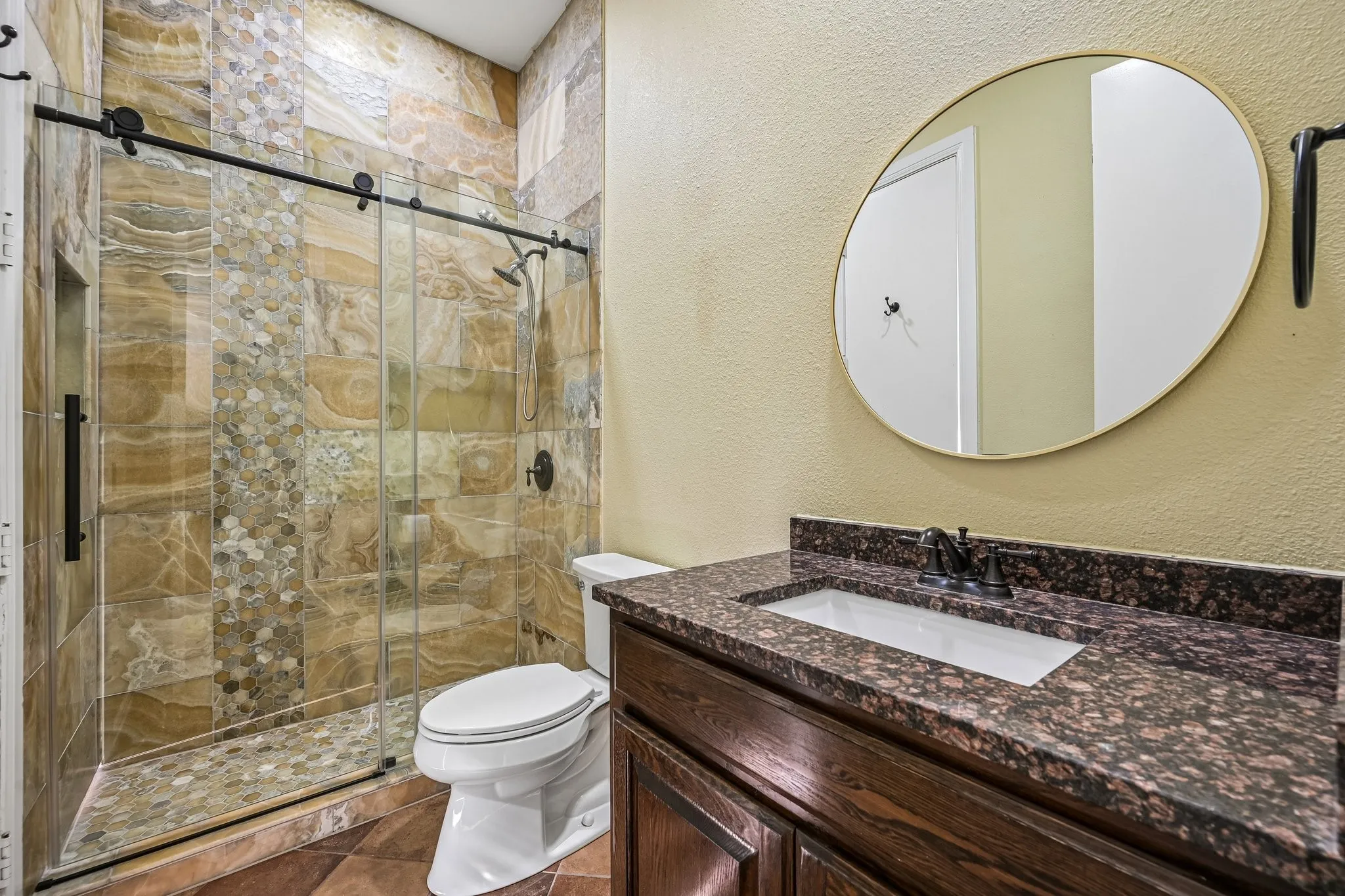 Second full sized bathroom located downstairs, near doors to pool