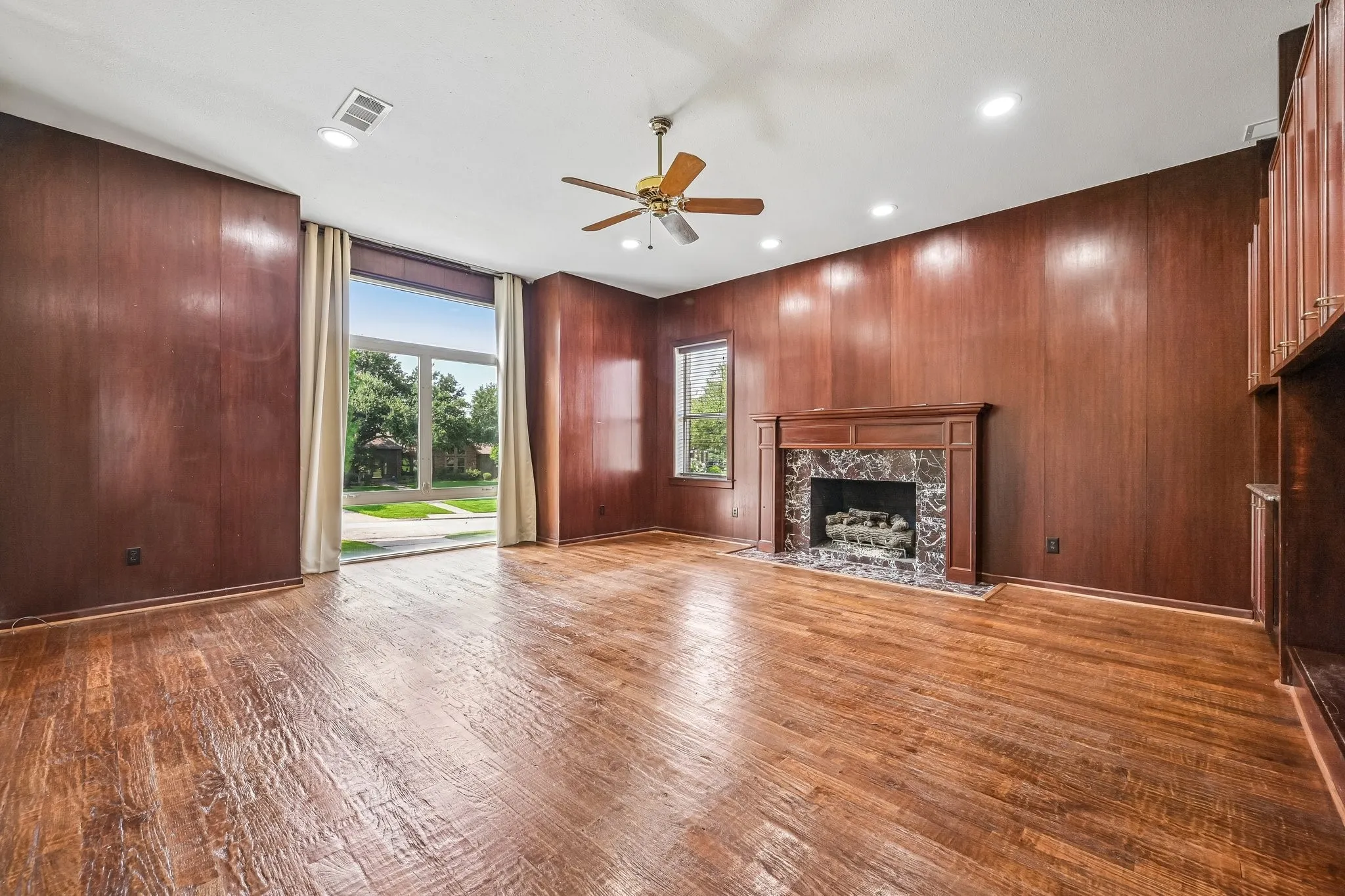 richly-paneled second living room with gorgeous built-ins and a second fireplace