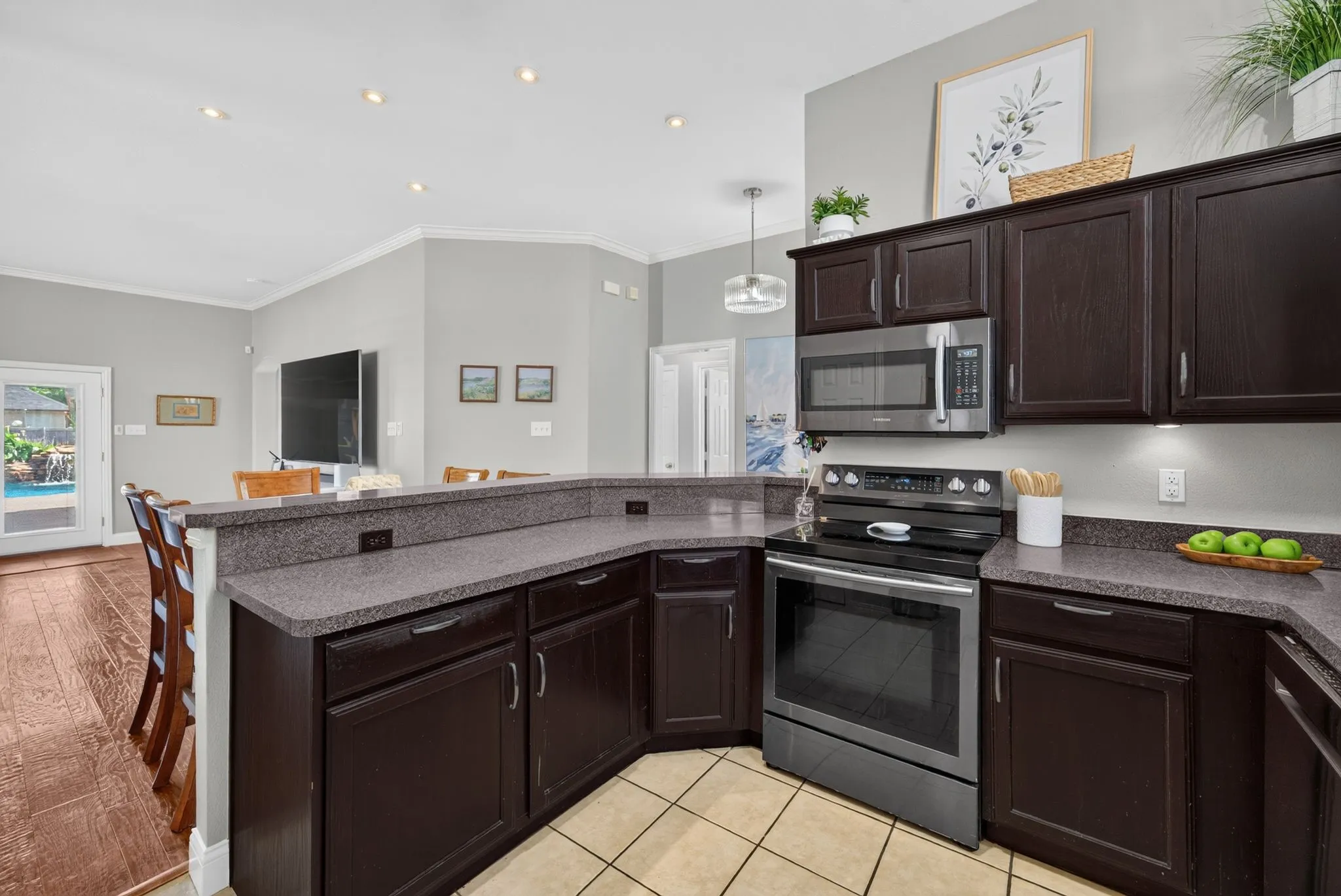 Kitchen featuring dark wood-finish cabinetry, speckled countertops, and stainless steel appliances