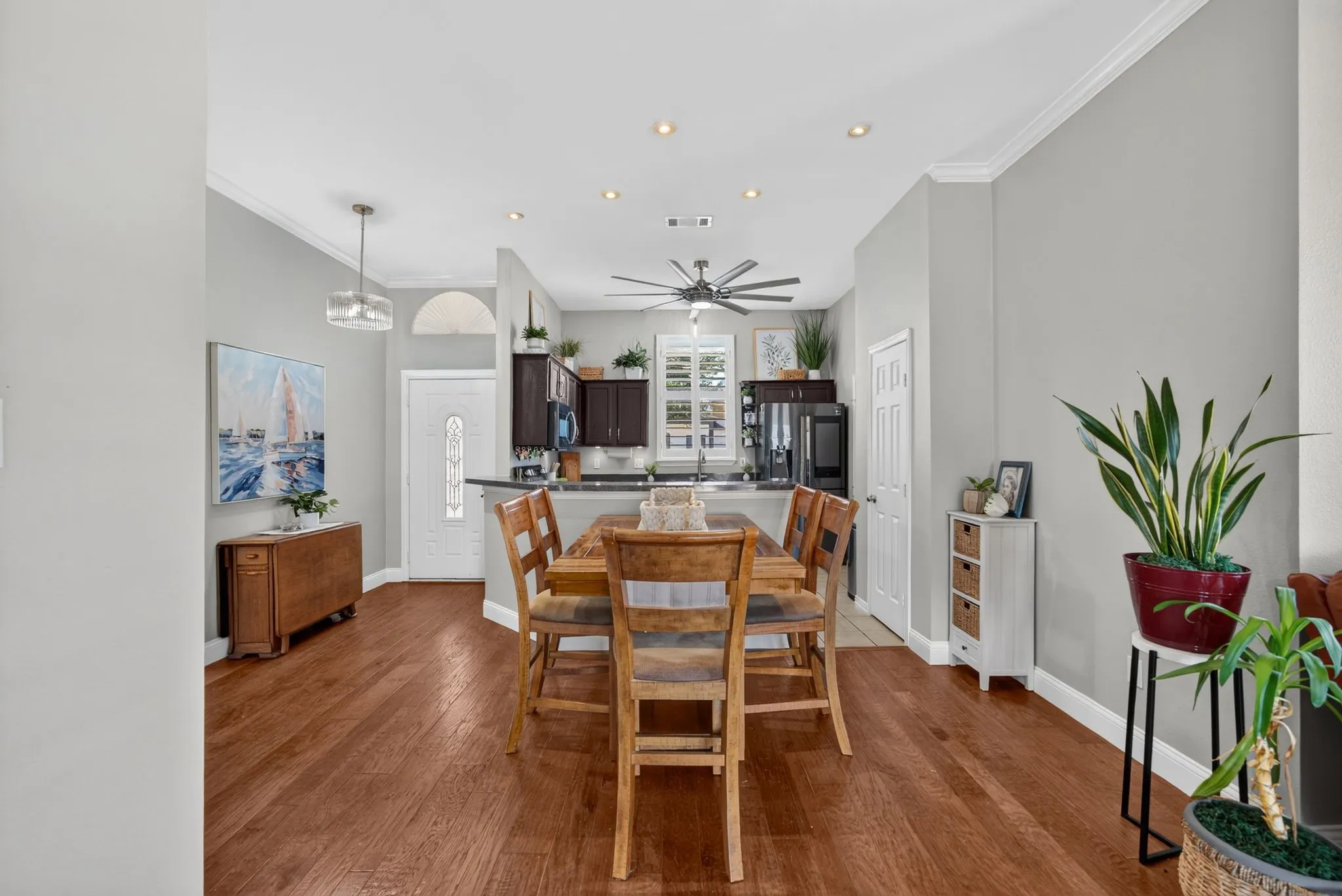 Dining area with wood-finish flooring, recessed lighting, and crown molding