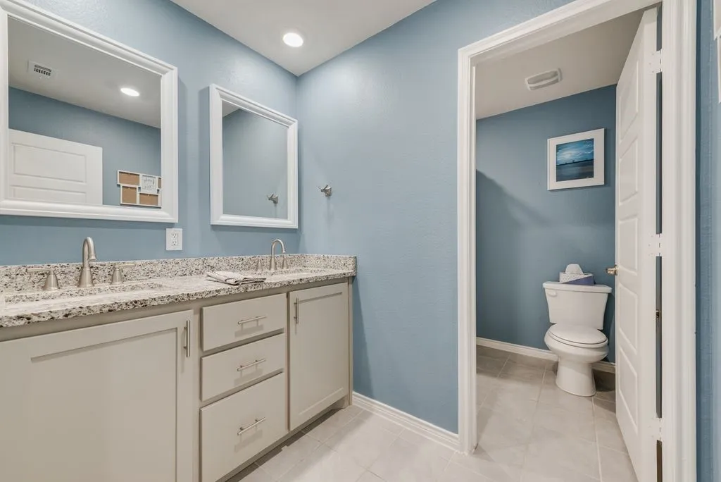 Double sinks and granite counters - high-end upgrade,  Framed mirrors and recessed lighting.