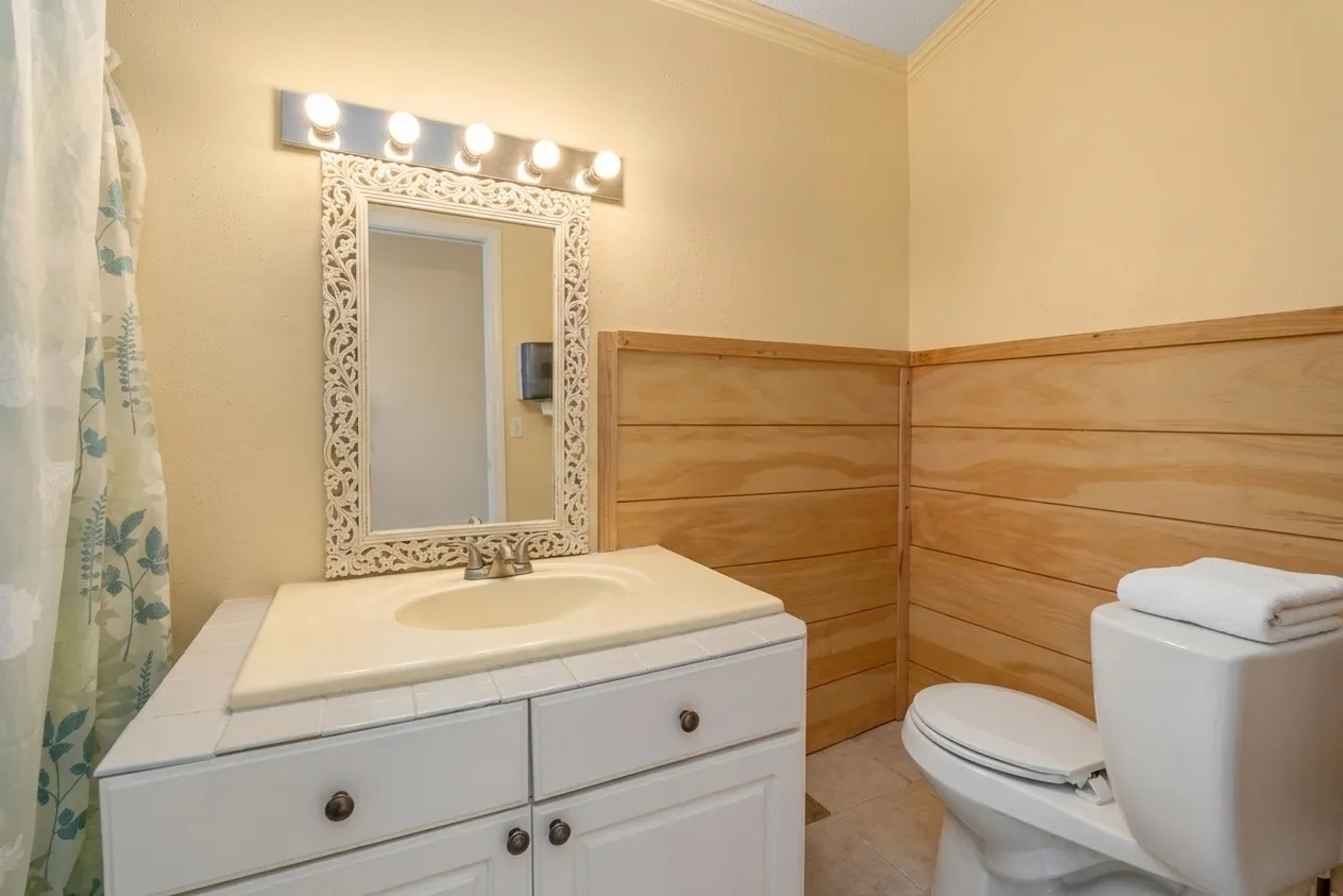 Bathroom vanity with a white integrated sink, chrome faucet, and decorative framed mirror