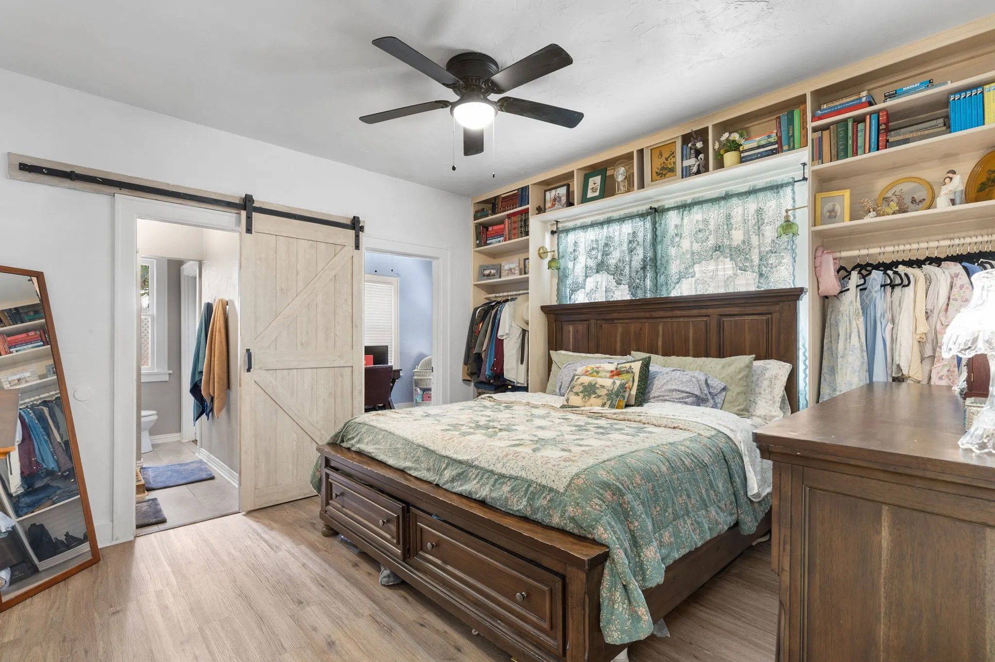 Primary bedroom featuring wood-like flooring and custom-built shelving