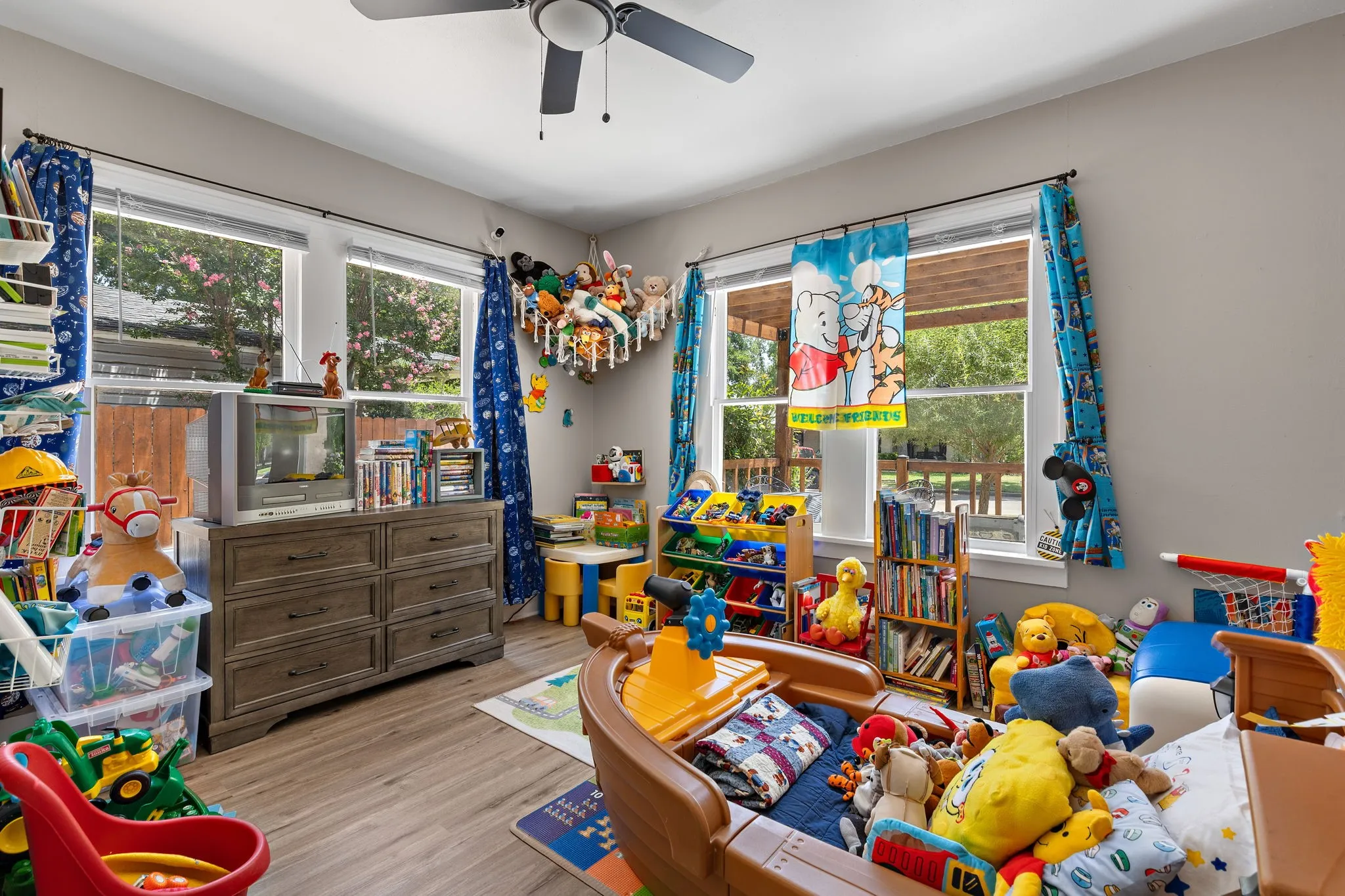 Bedroom featuring a ceiling fan with integrated lighting and four windows