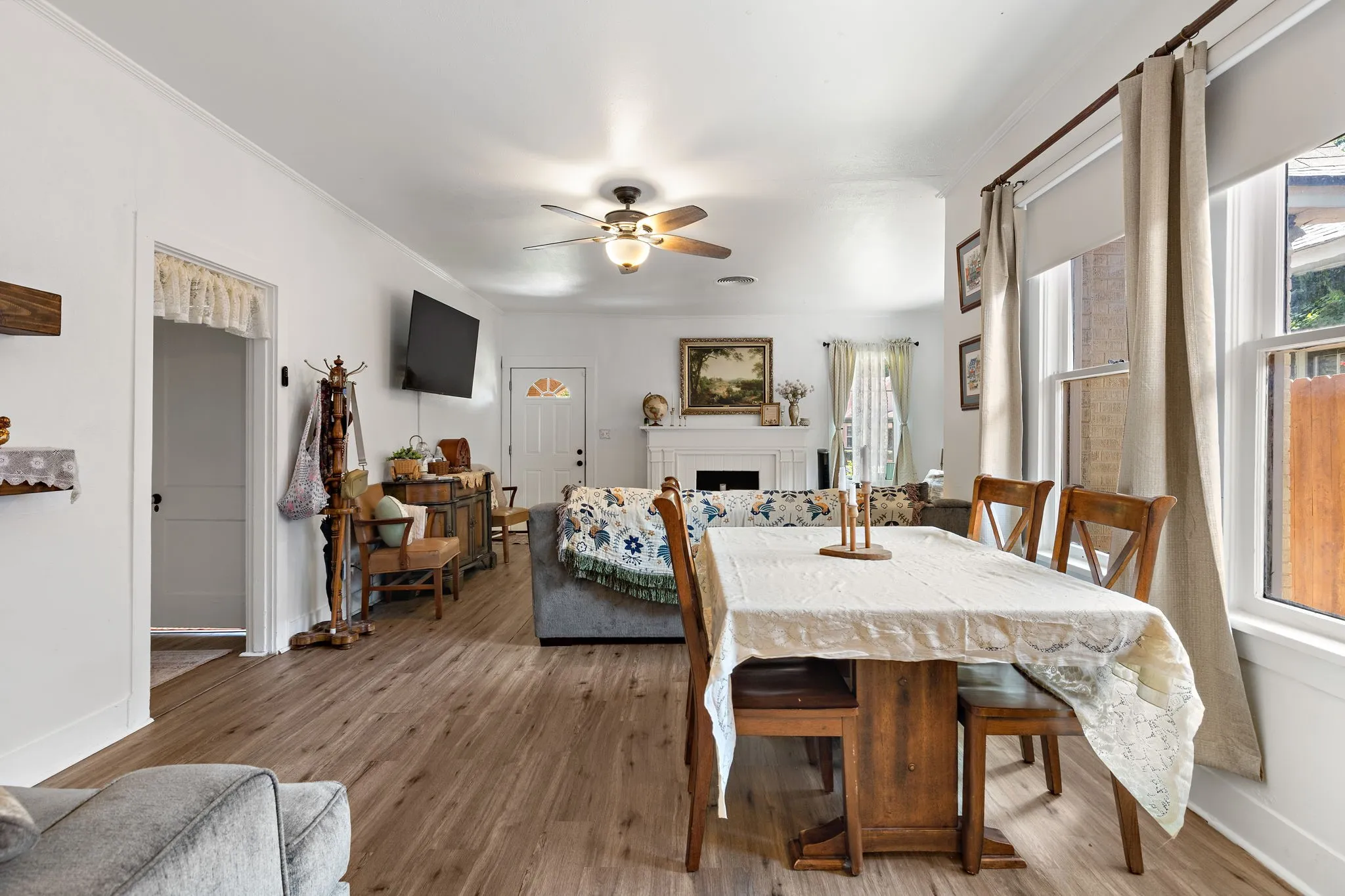Dining area featuring two large windows with roller shades and curtains