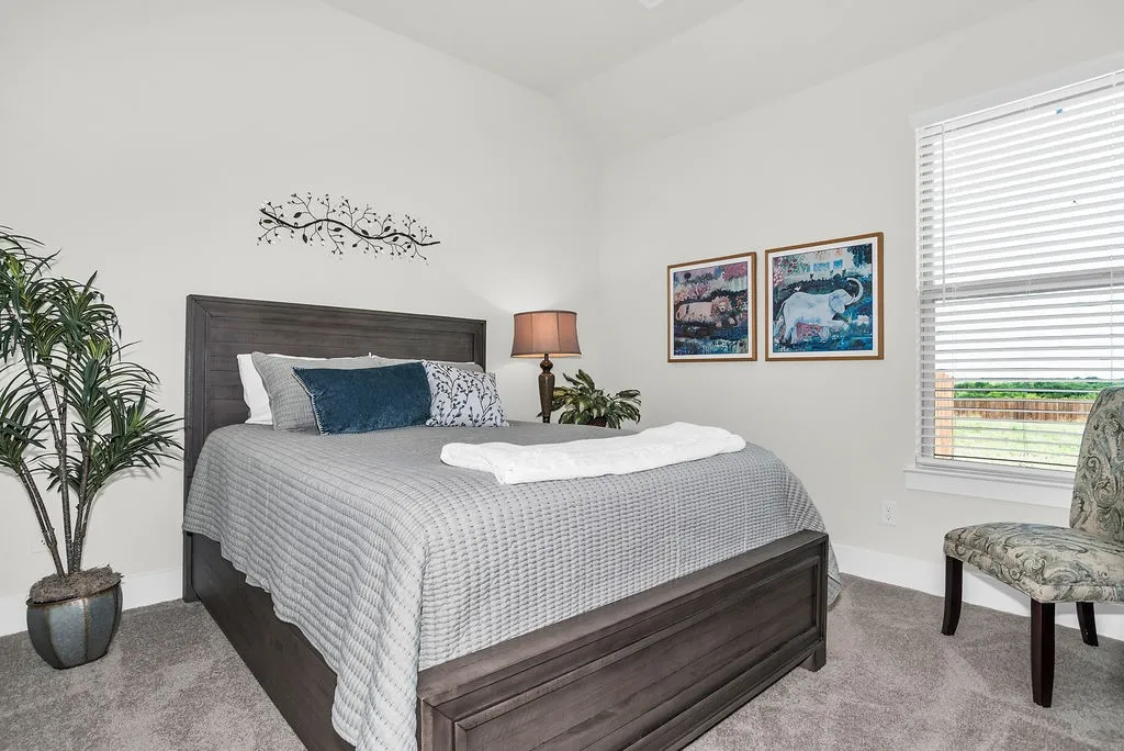 Carpeted room featuring light-toned walls and a window with walk in closet