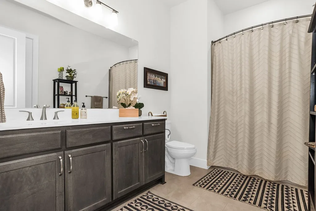 Bathroom featuring dark wood-finish cabinetry, pendent lighting, and brushed nickel fixtures