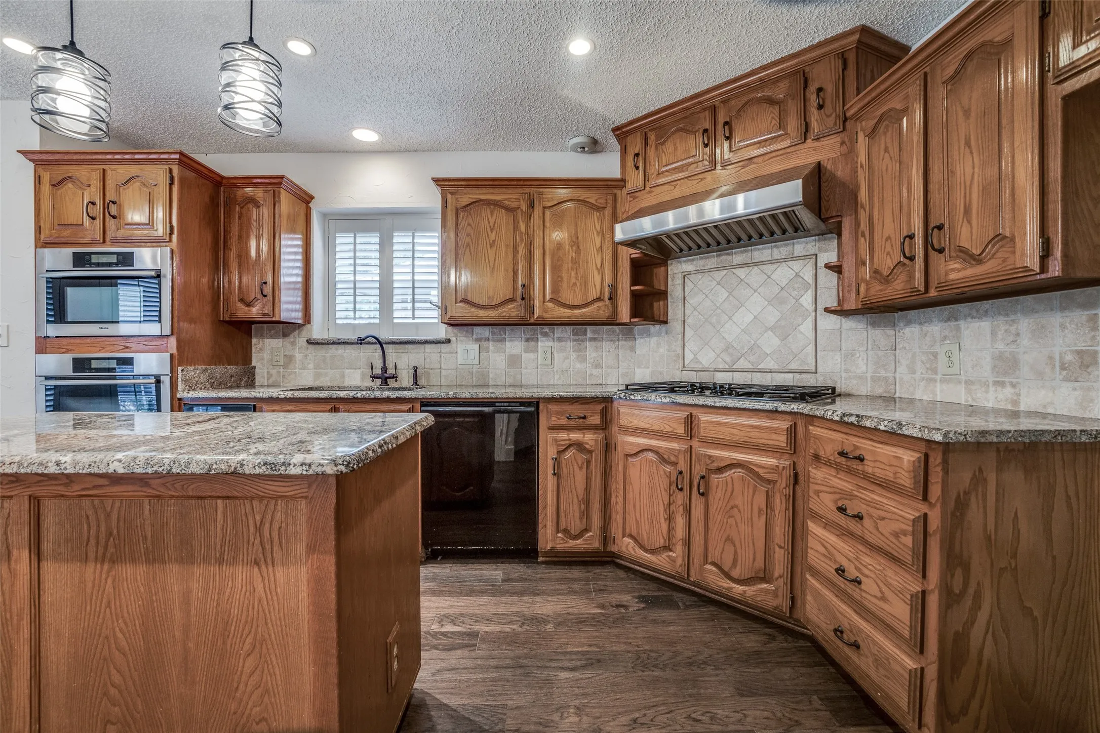 Kitchen featuring wood-finish cabinetry, granite countertops, and stainless steel appliances