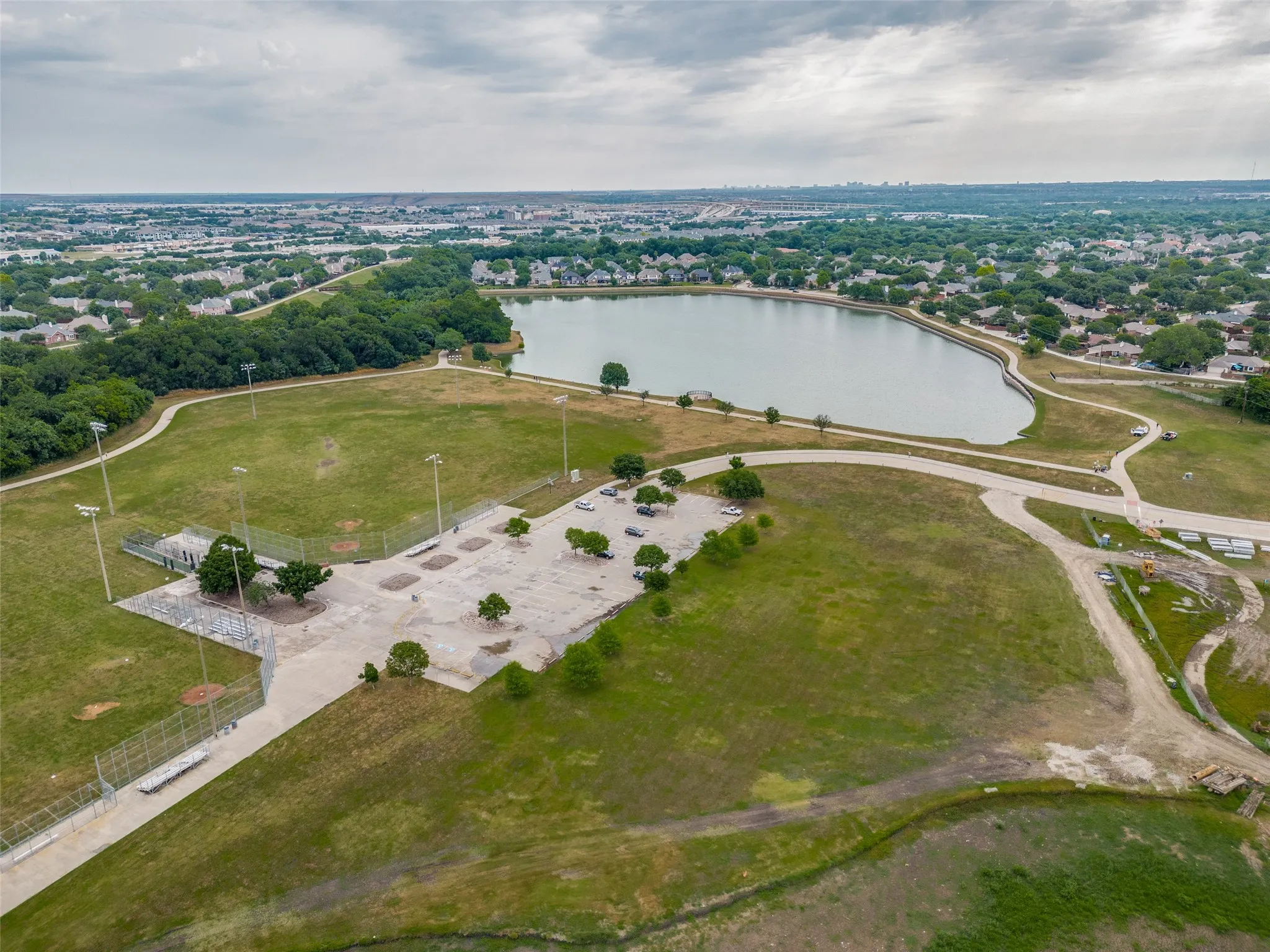 Aerial perspective showcasing a large body of water bordered by a paved walking path