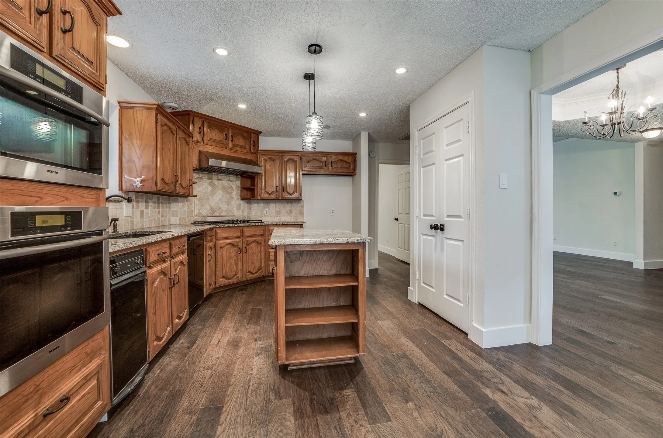 Kitchen featuring wood-finish flooring, recessed lighting, and a center island with open shelving