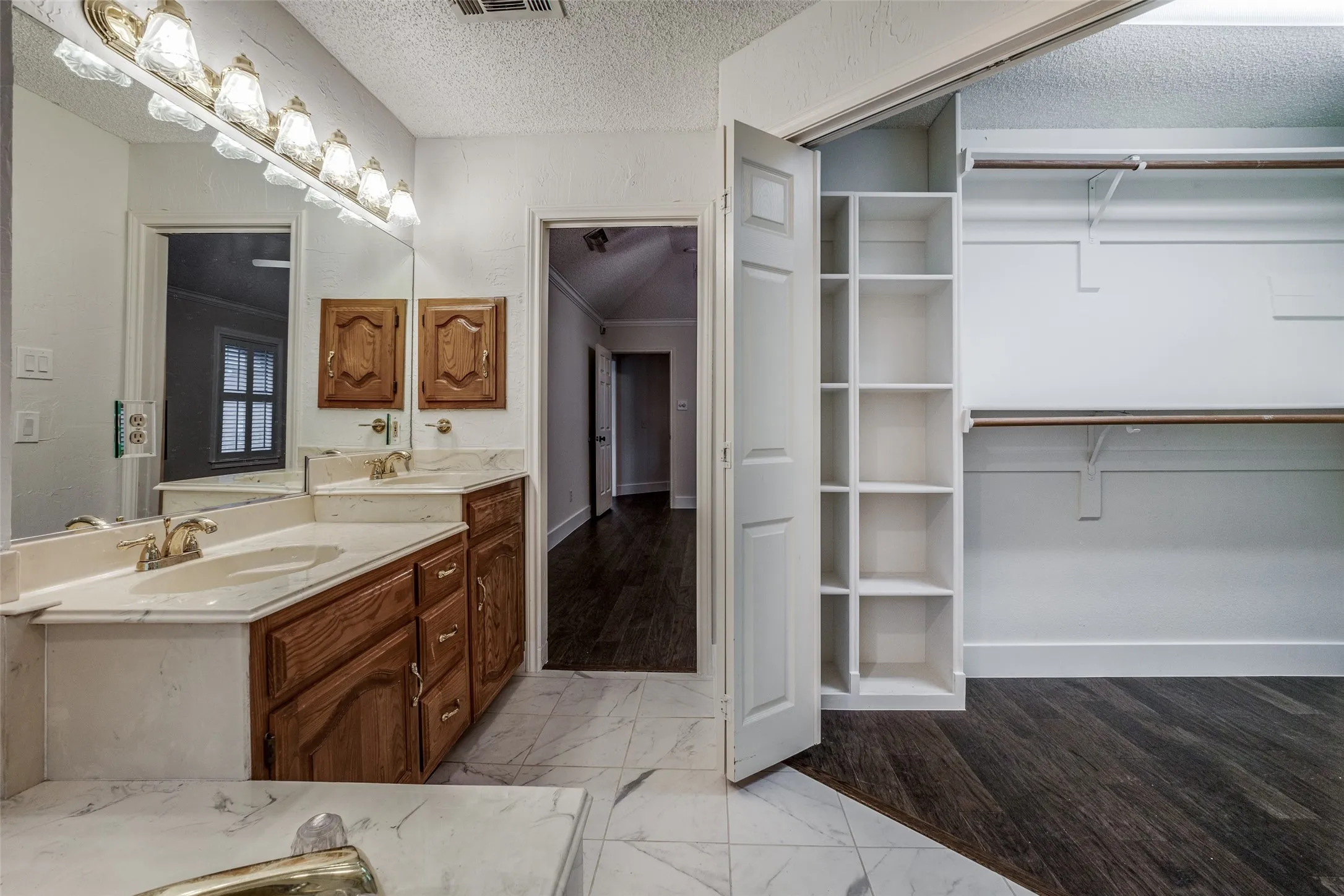 Bathroom featuring a dual vanity with light-toned countertops and wood-finish cabinetry