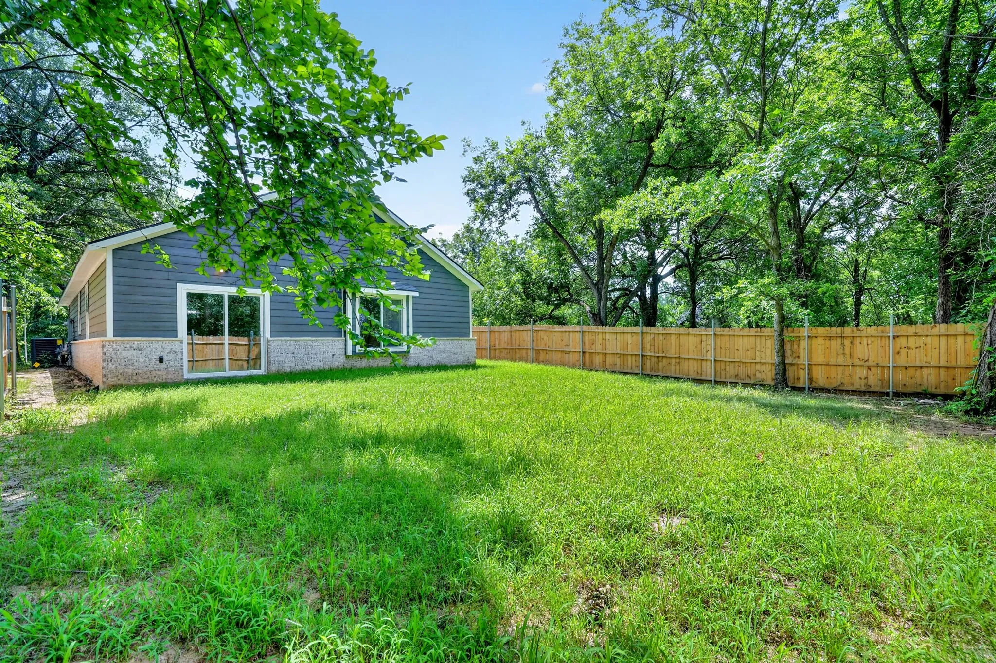 Rear exterior featuring gray siding and a stone foundation