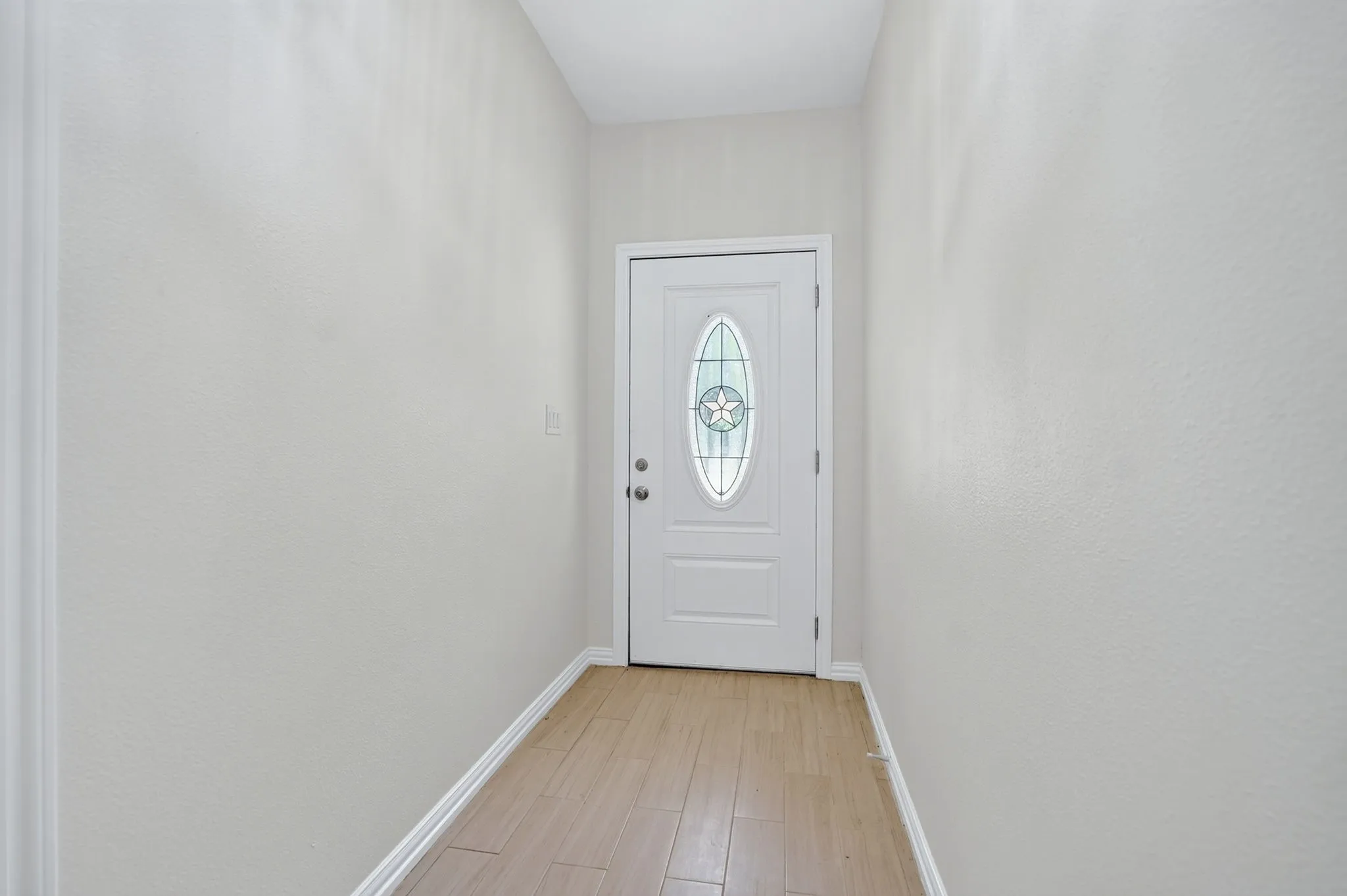 Entryway with wood-finish flooring, white baseboards, and light-toned walls