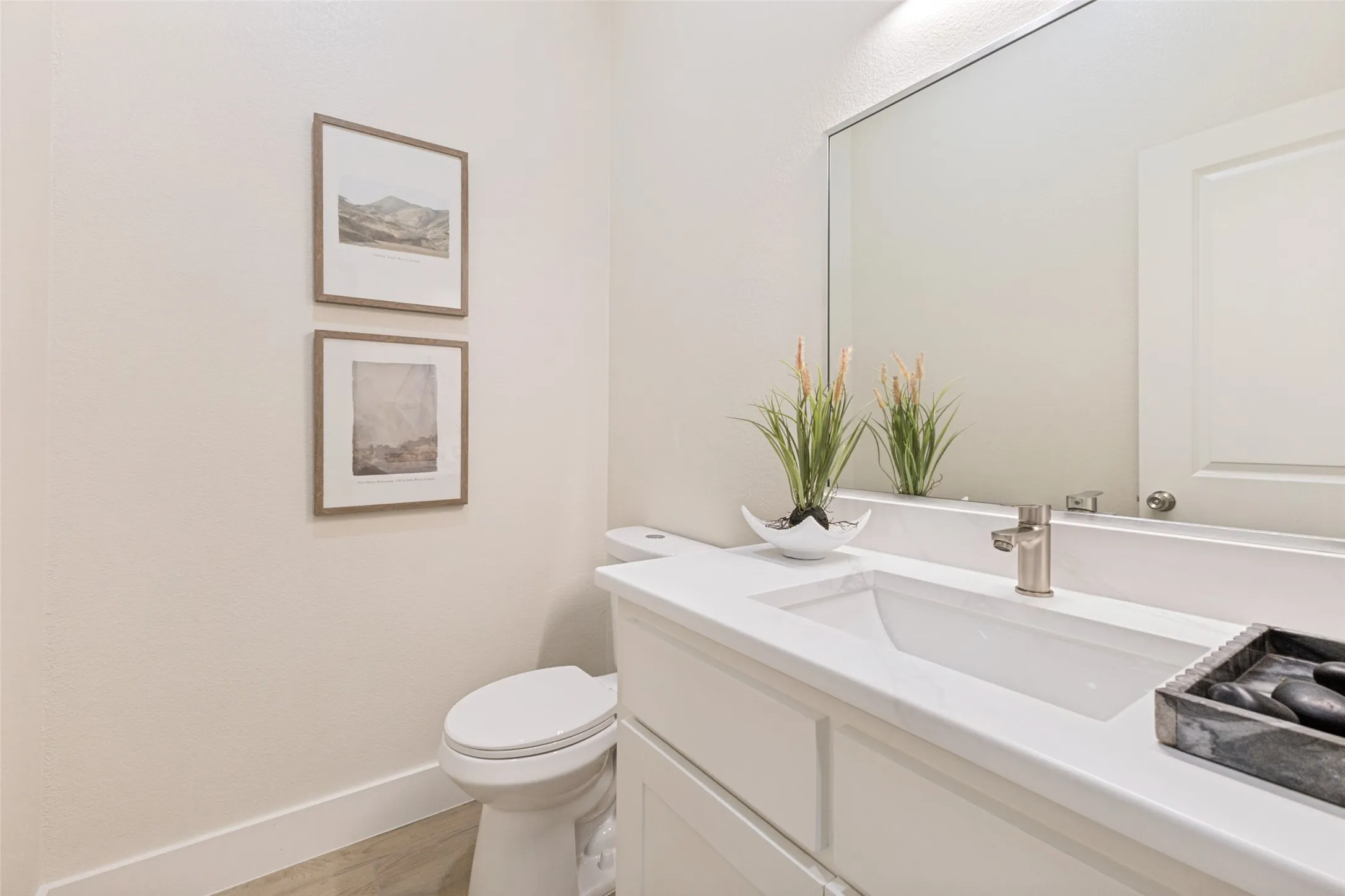 Bathroom featuring a contemporary vanity with a rectangular undermount sink, a polished chrome faucet, and a large wall-mounted mirror