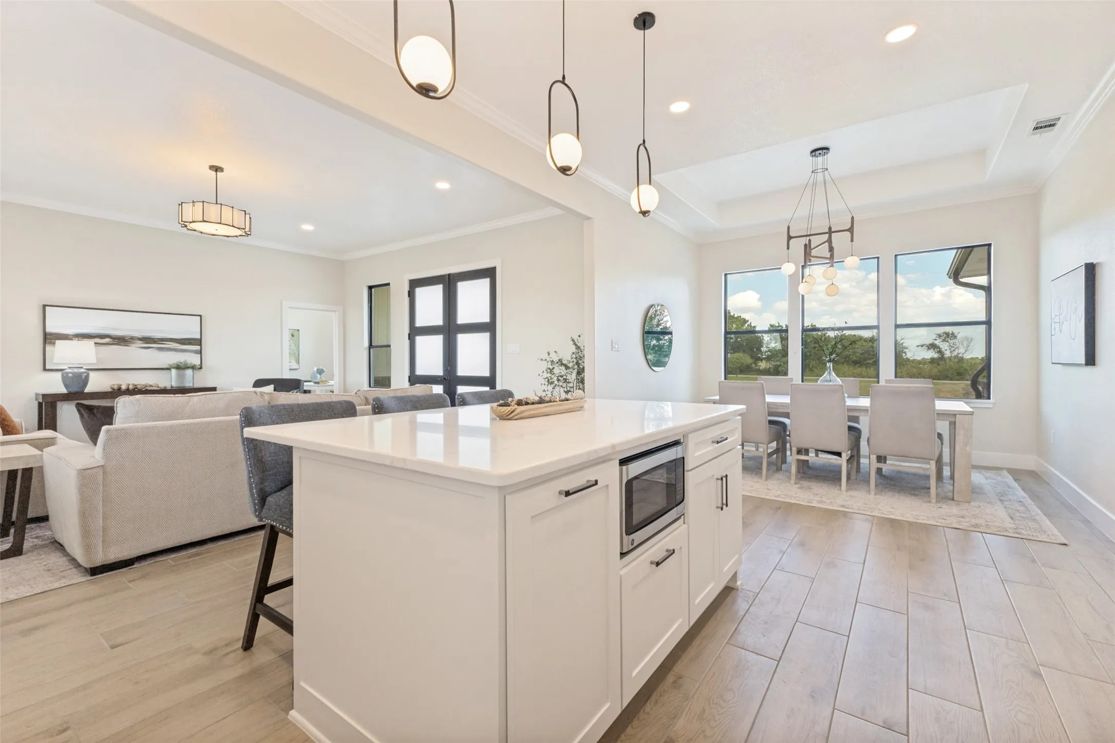Kitchen island with quartz countertop, integrated microwave, and pendant lighting