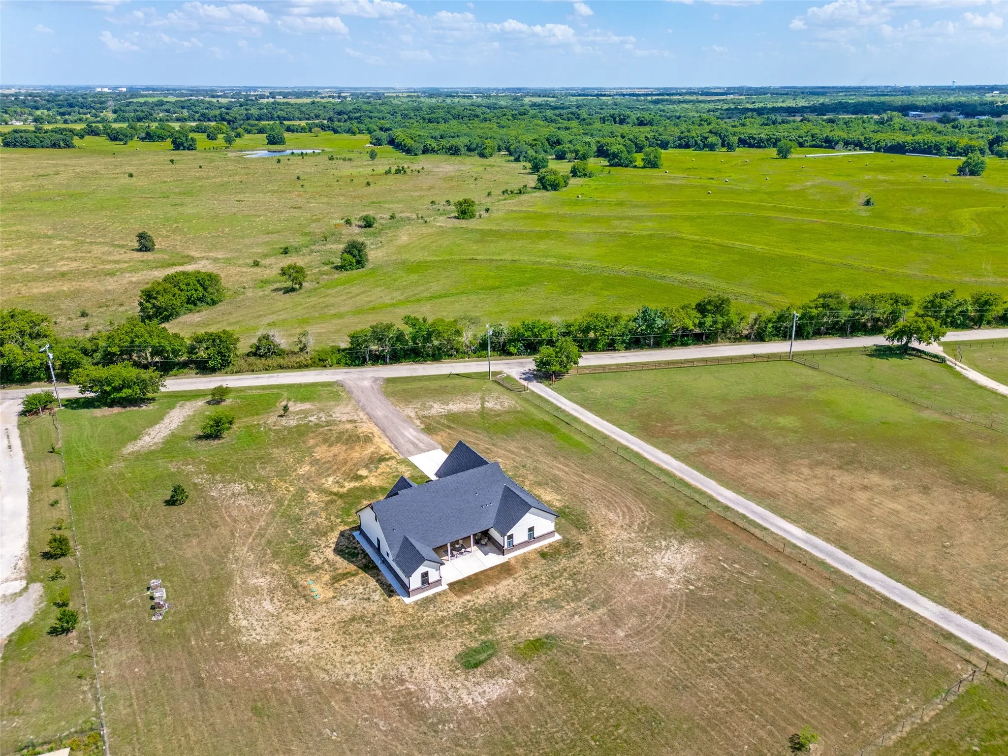 Contemporary ranch-style residence featuring a dark shingle roof and white exterior siding