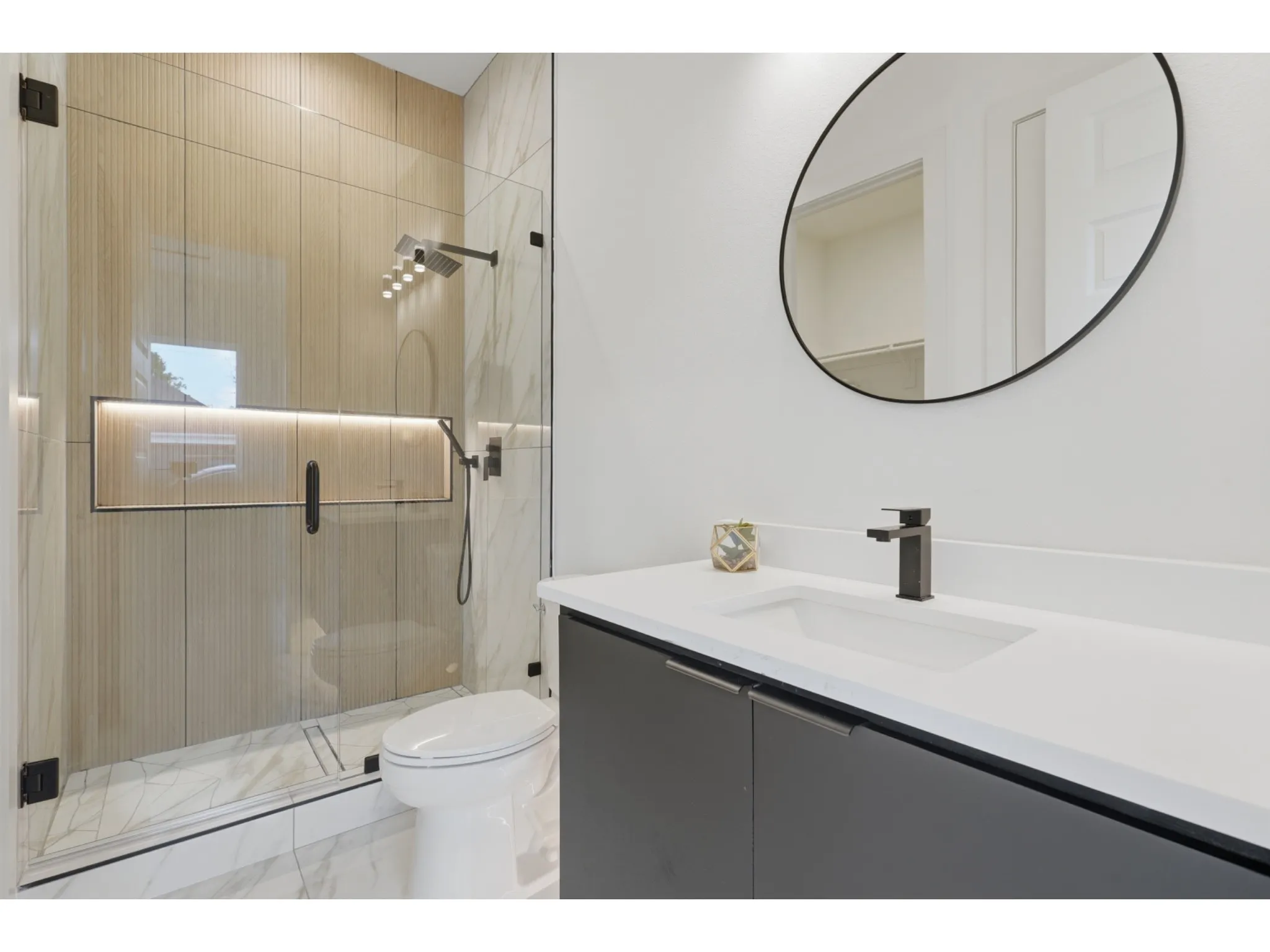 White vanity with an integrated sink and matte black faucet, paired with a circular mirror