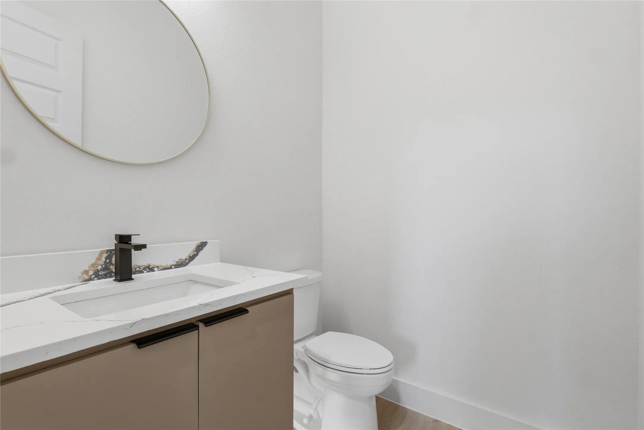 Contemporary vanity featuring an integrated rectangular sink, stone-finish countertop, and matte black faucet