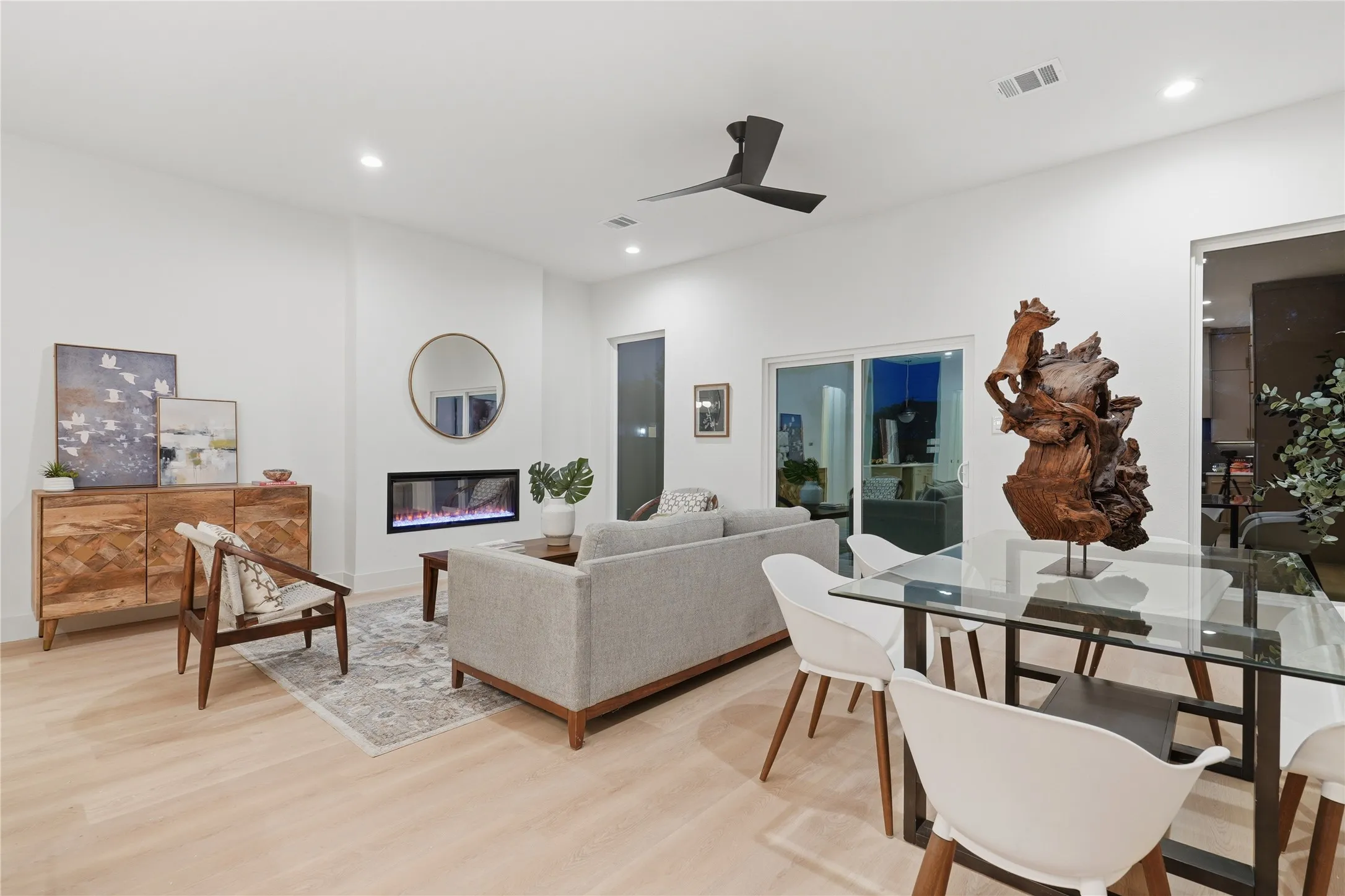 Bright open-concept living space featuring wood-finish flooring, recessed lighting, and a modern ceiling fan