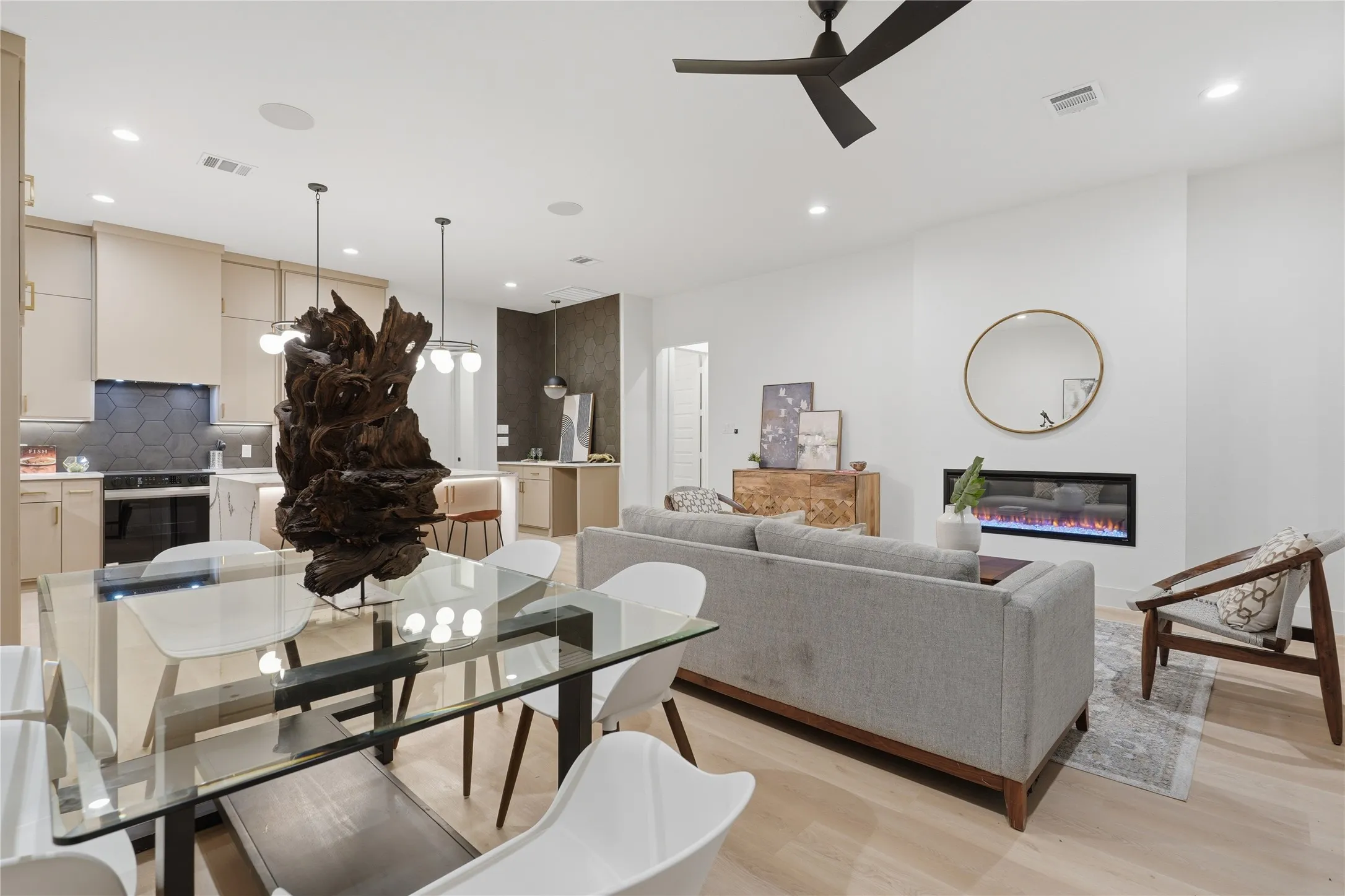 Open-concept living space featuring wood-finish flooring, a linear electric fireplace, and a contemporary ceiling fan