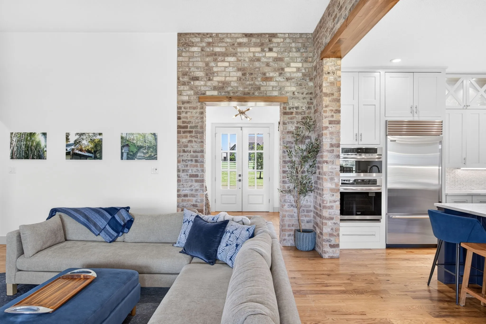 Exposed brick archway with French doors opening to outdoor space