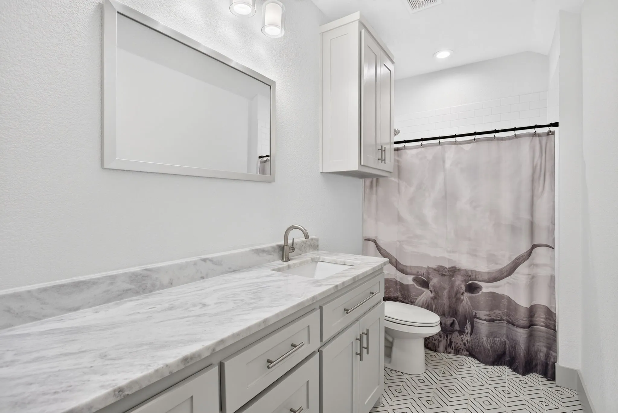 Bathroom featuring a vanity with a light-toned countertop, integrated sink, and brushed nickel faucet