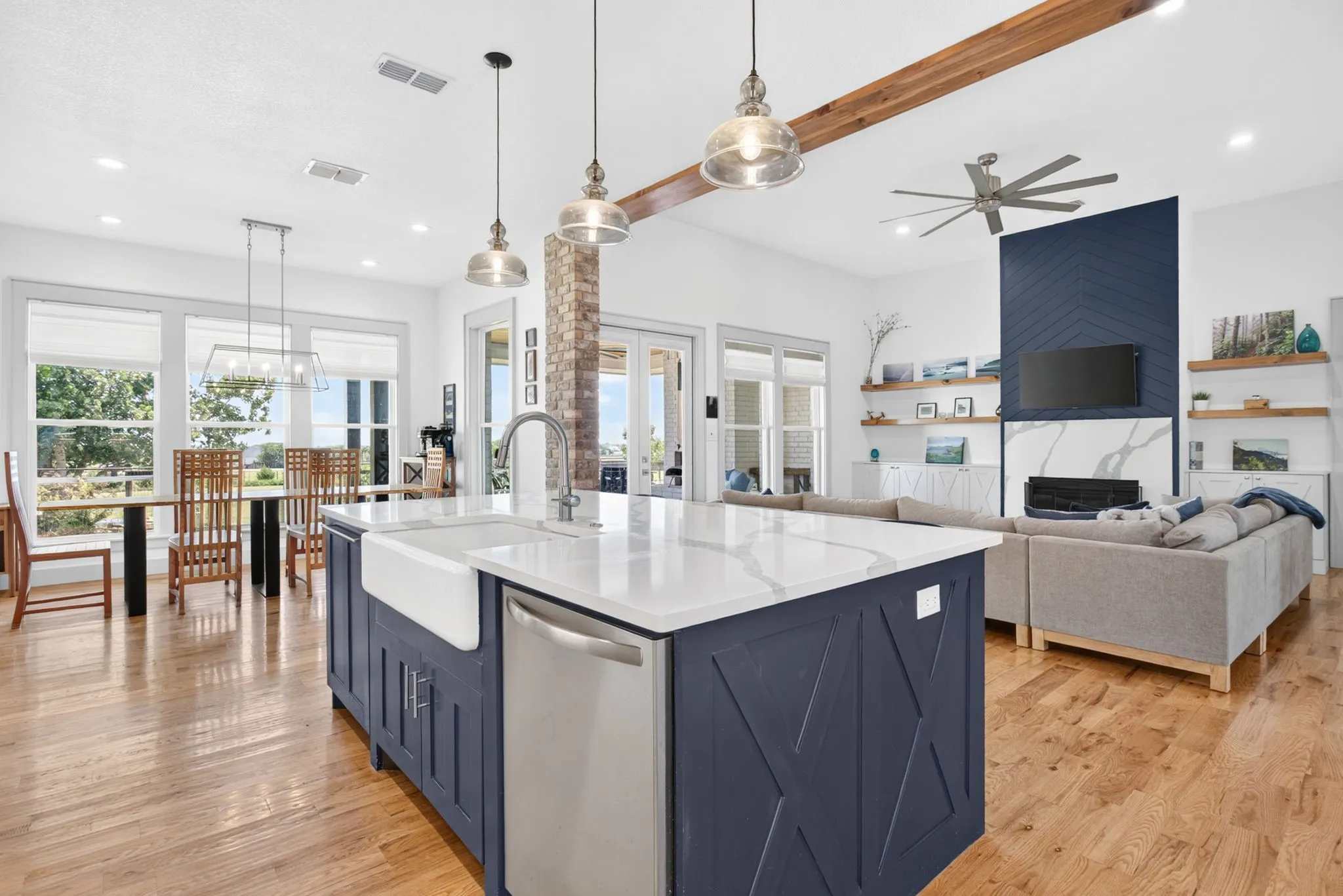 Kitchen island featuring a farmhouse sink, stainless steel dishwasher, and a white countertop