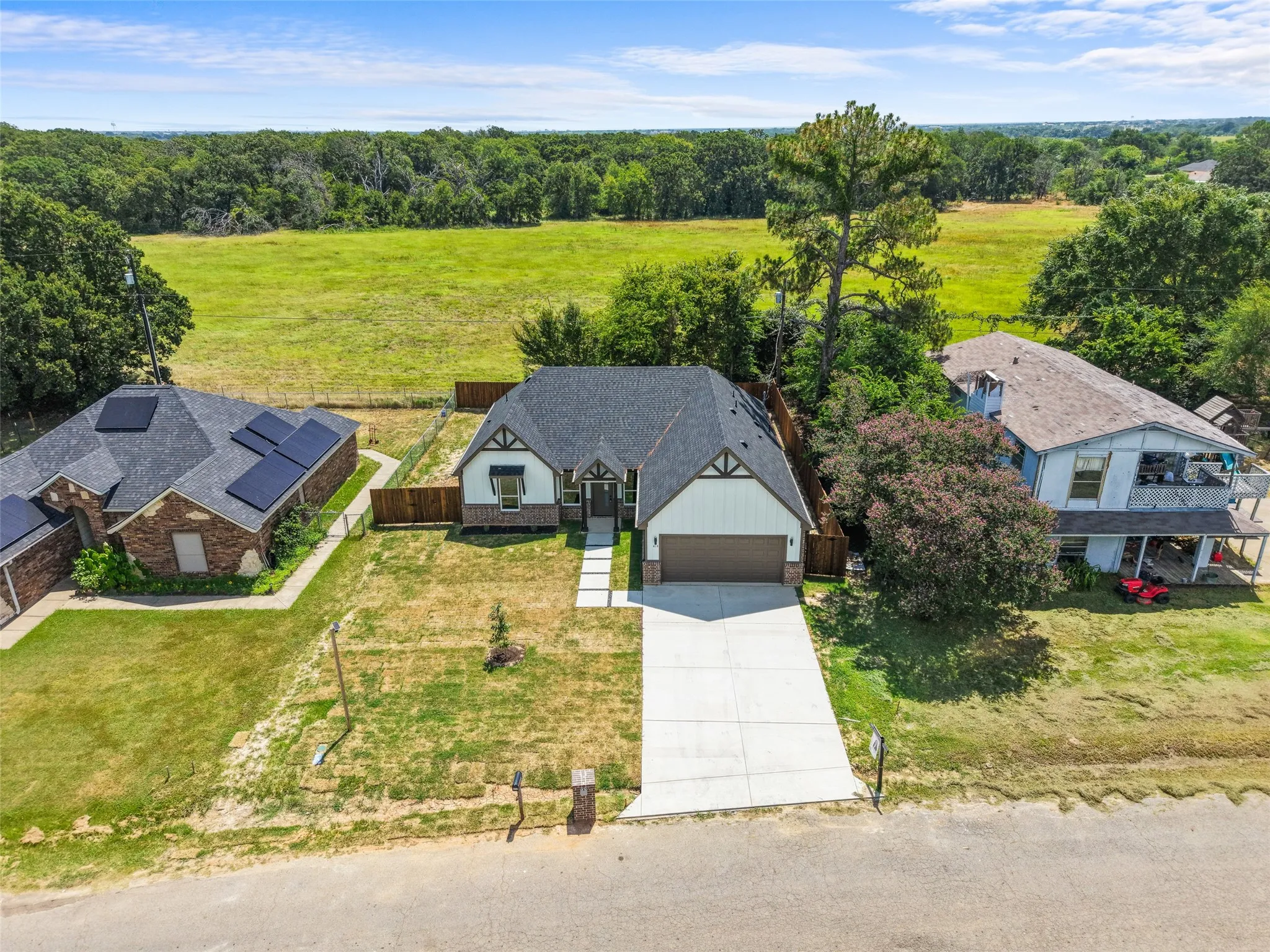 Modern Craftsman-style home with a dark shingle roof, white siding, and brown trim accents