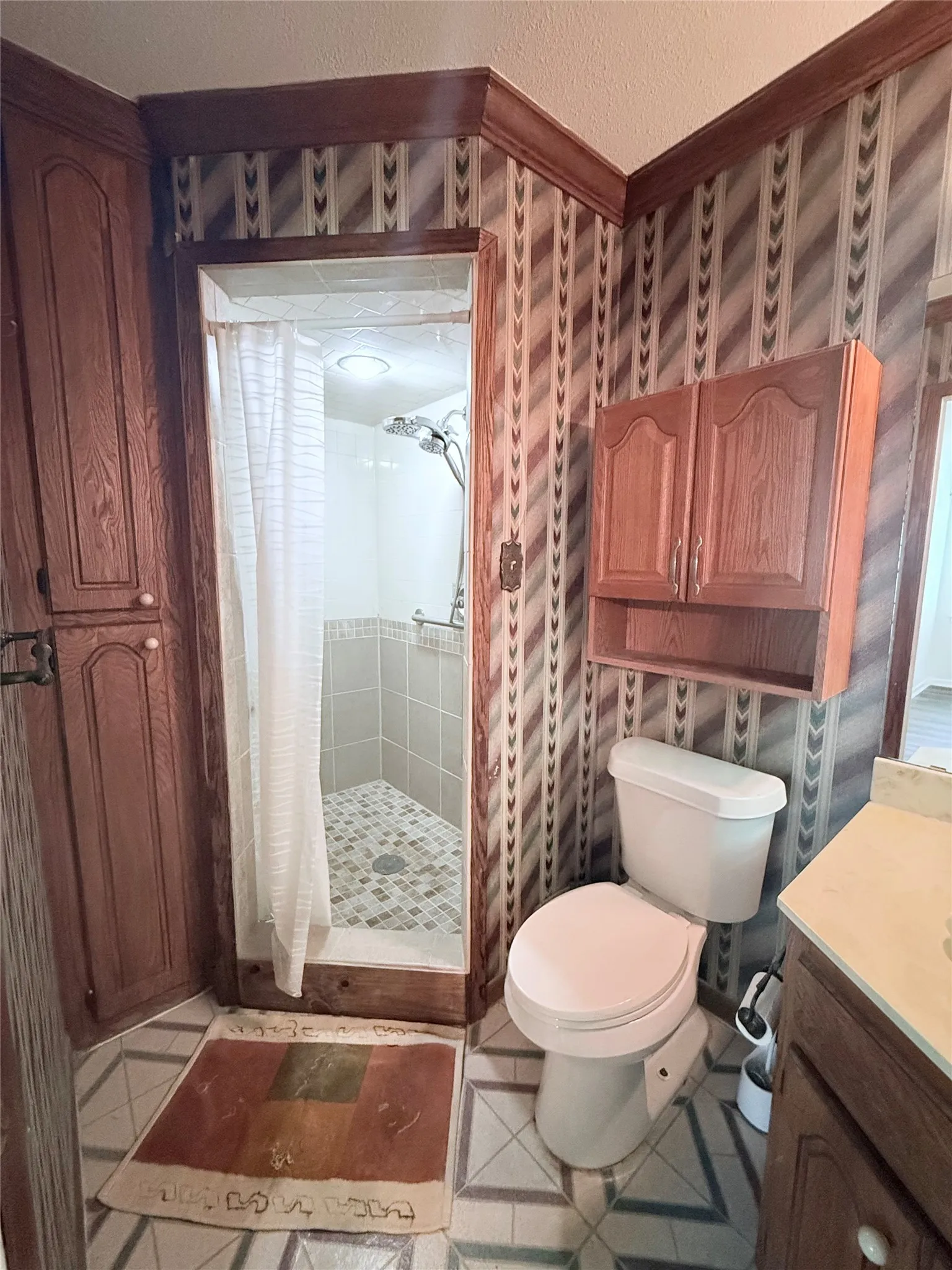 Tiled shower with a corner entry, featuring a multi-function showerhead
