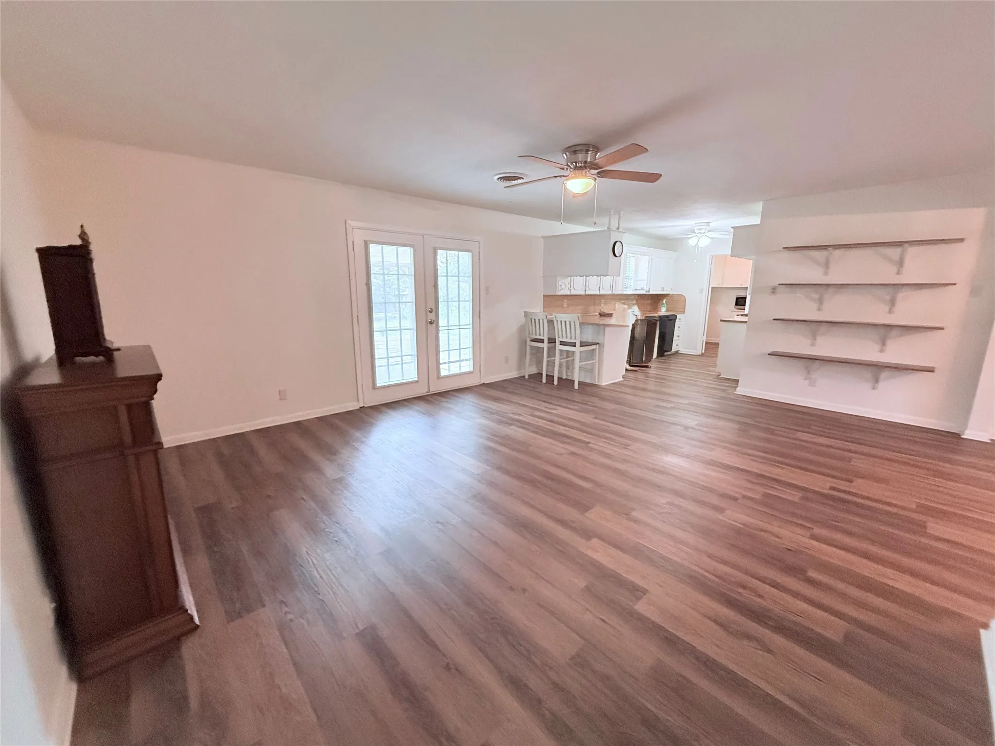 Spacious common area featuring wood-finish flooring and light neutral wall tones