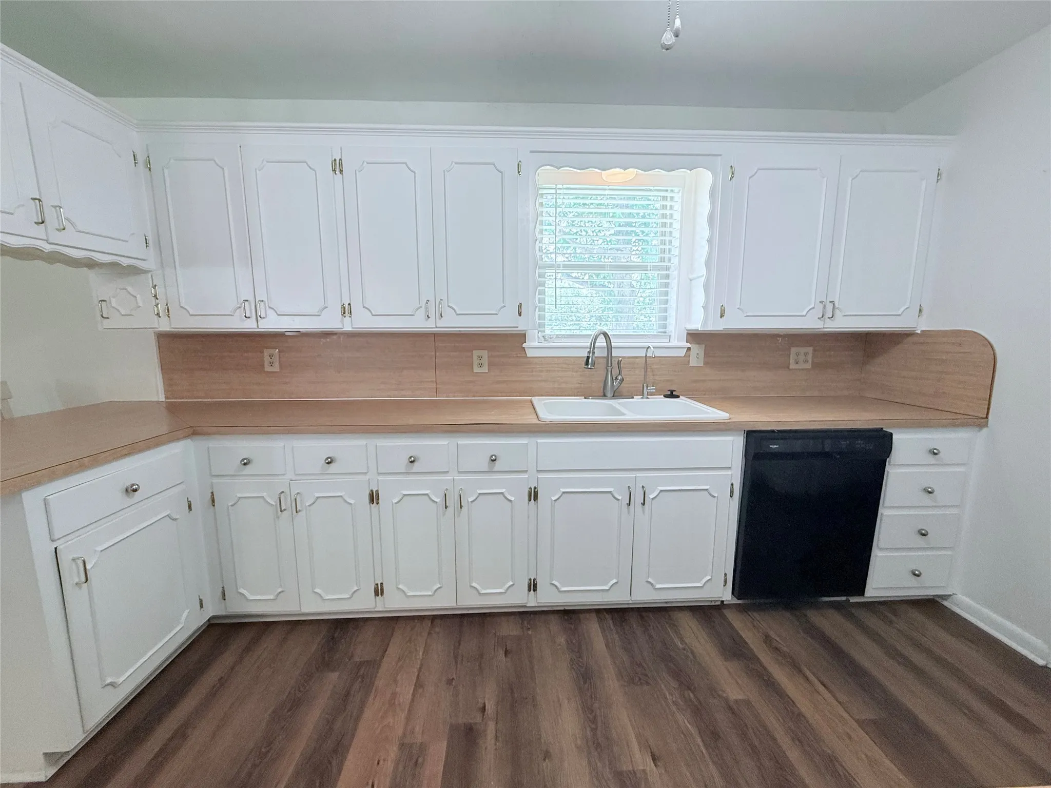 Kitchen featuring white cabinetry, light wood-finish countertops, and wood-finish flooring