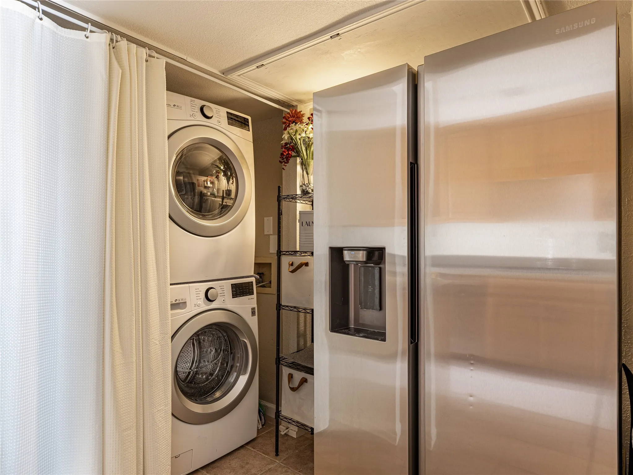Clean, organized laundry room equipped with a space-saving stackable washer and dryer.